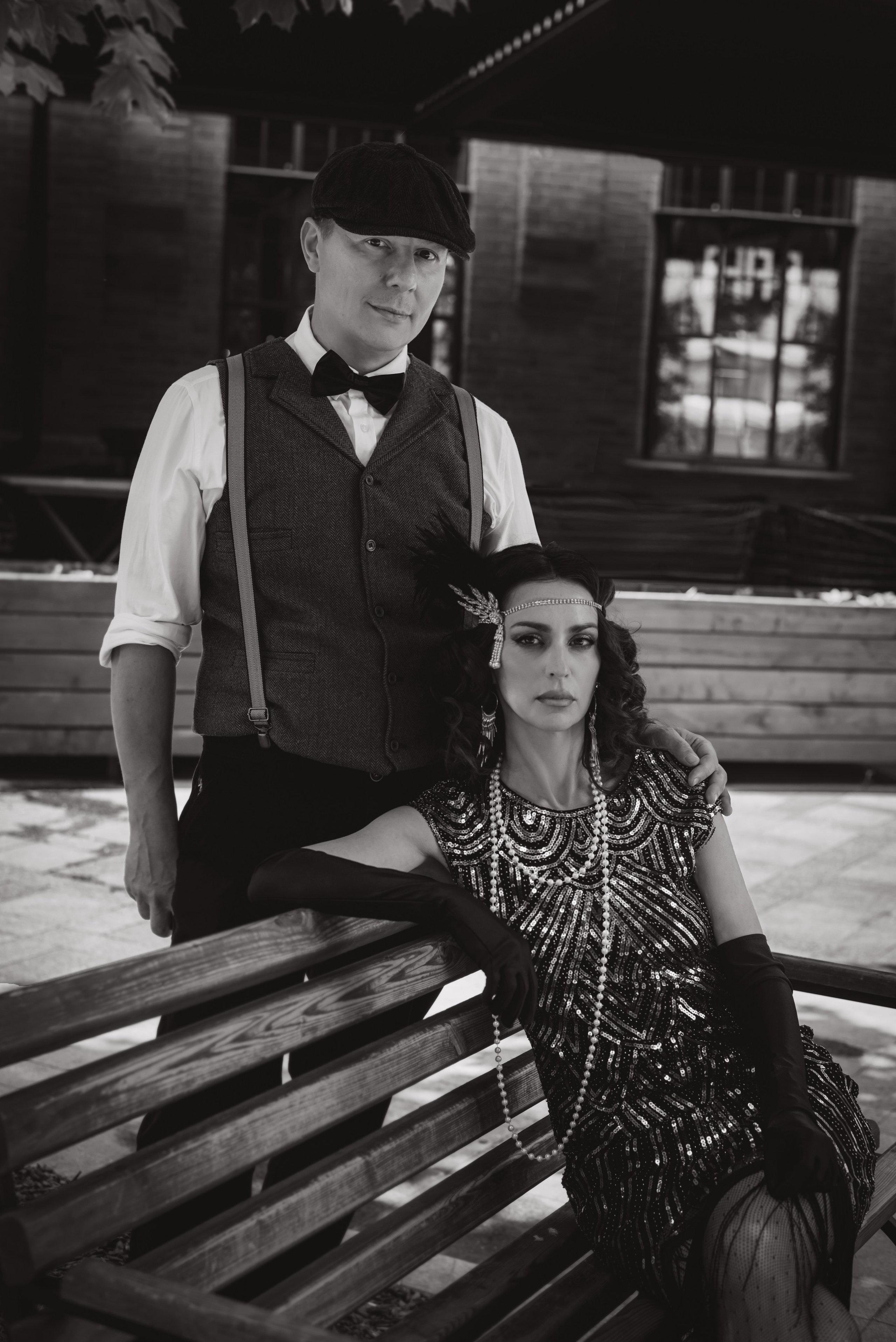 Женщина сидит на скамейке, мужчина стоит рядом в городе