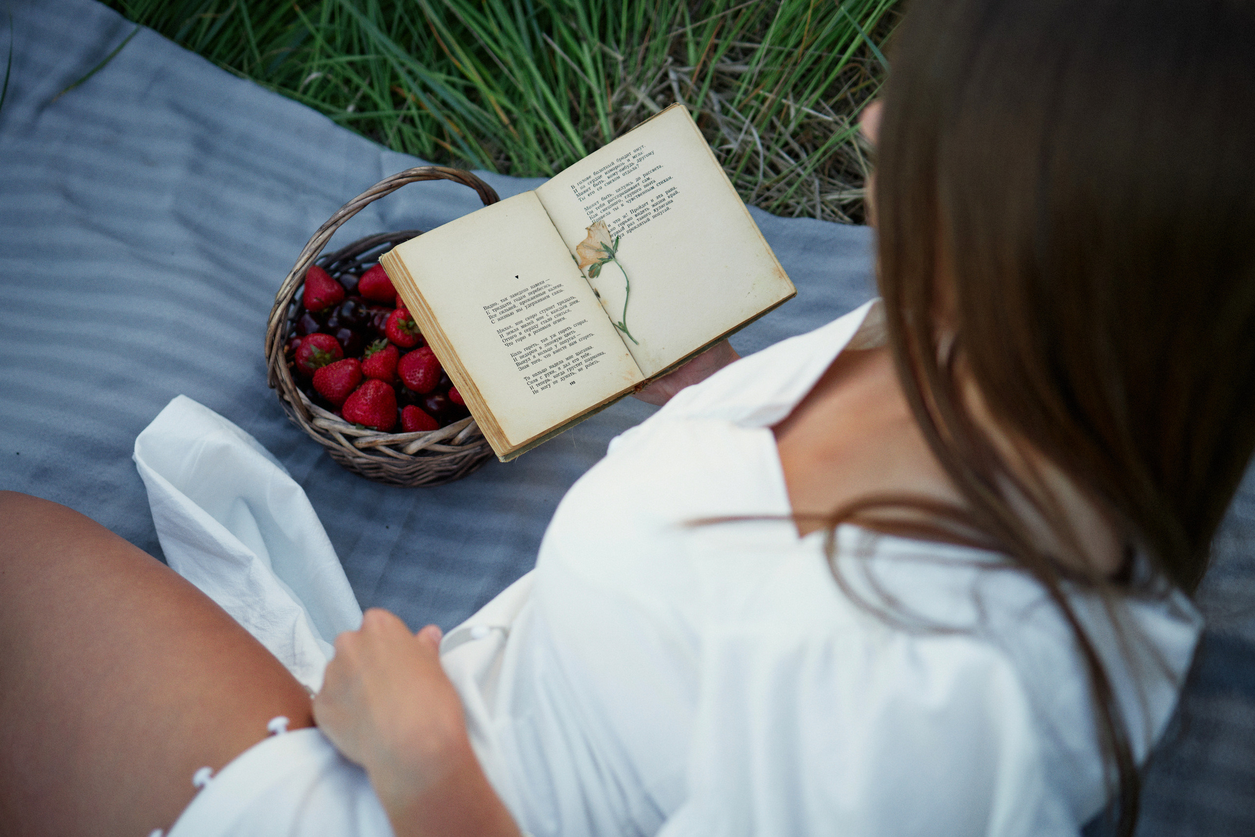 Фотосессия девушки с книгой на пледе в поле