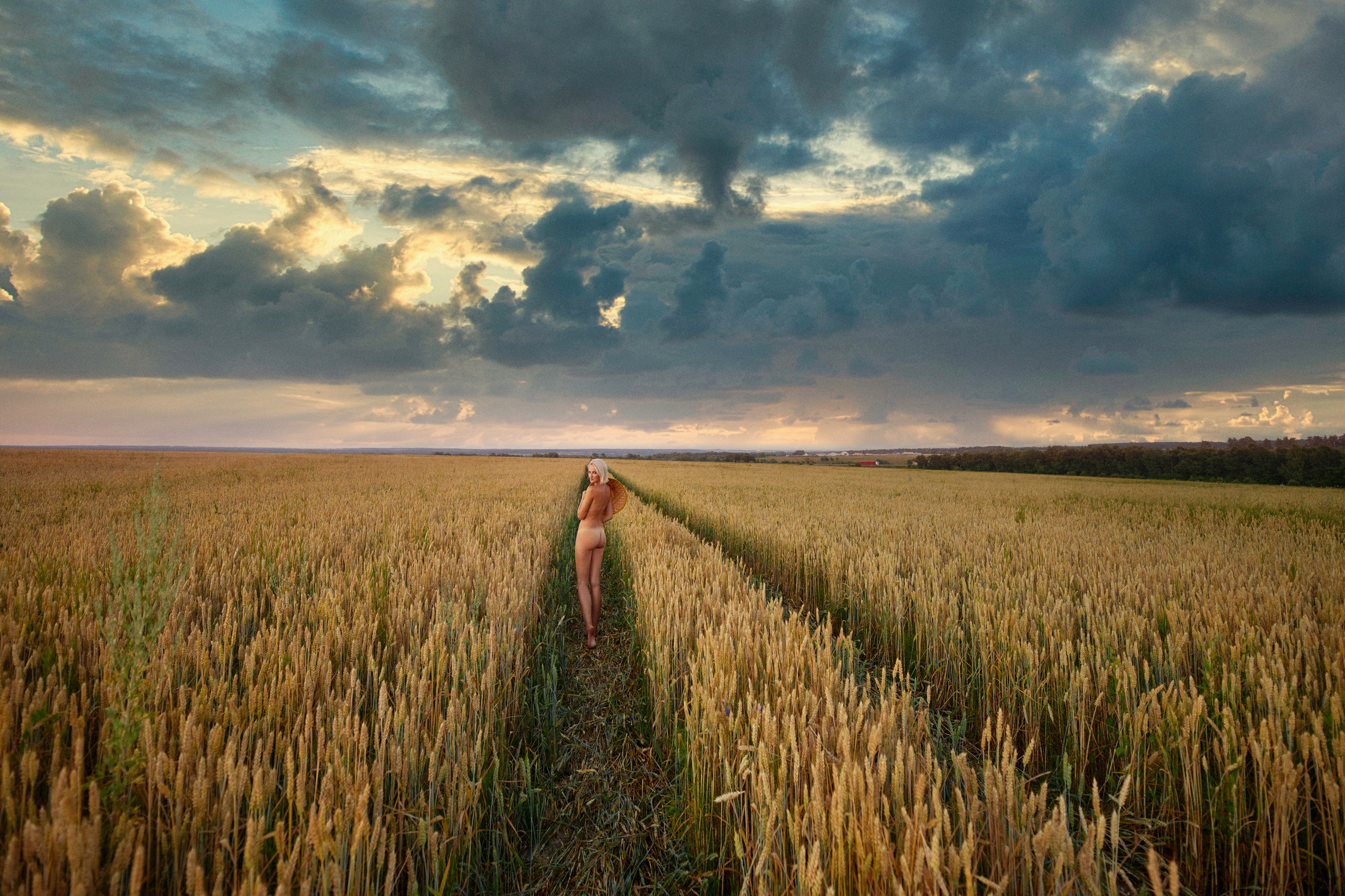 Голая девушка гуляет на природе в поле пшеницы
