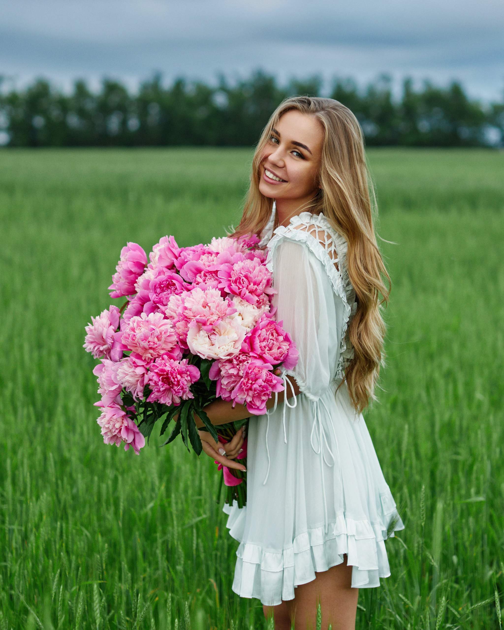 Счастливая девушка с большим букетом пионов. Фотосессия на природе