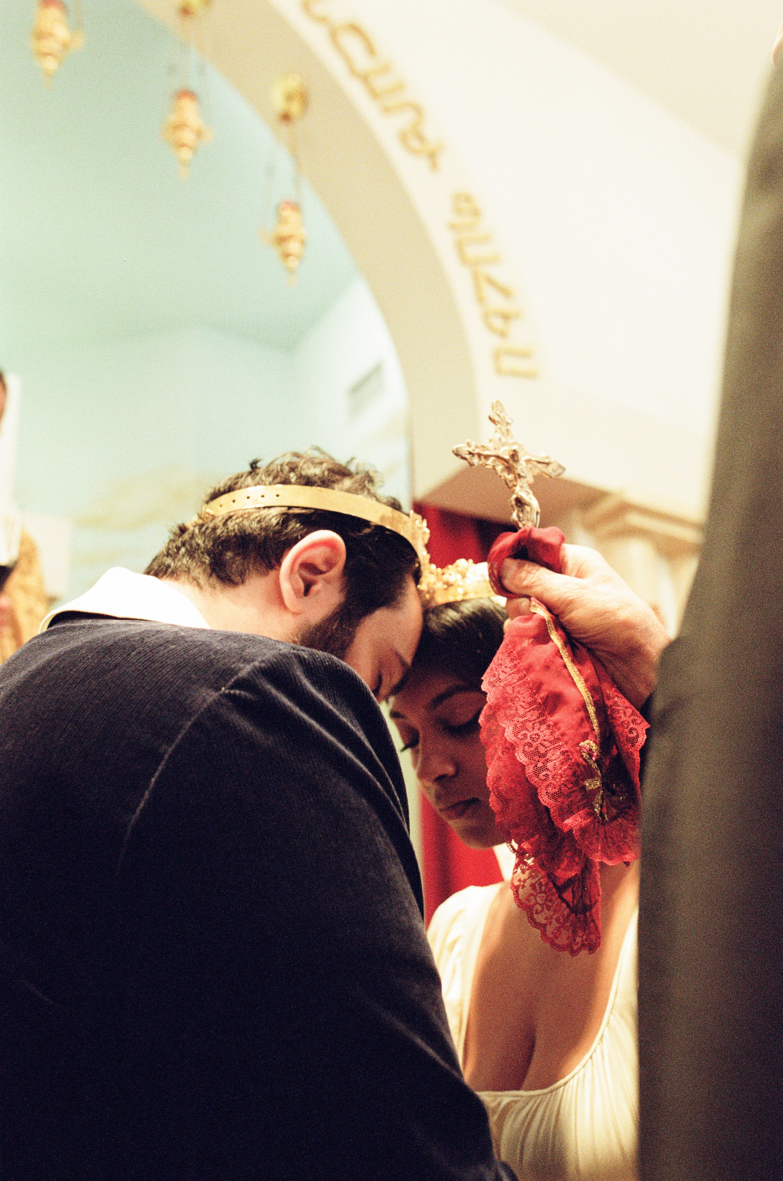 bride and groom under wedding bands during their church wedding ceremony