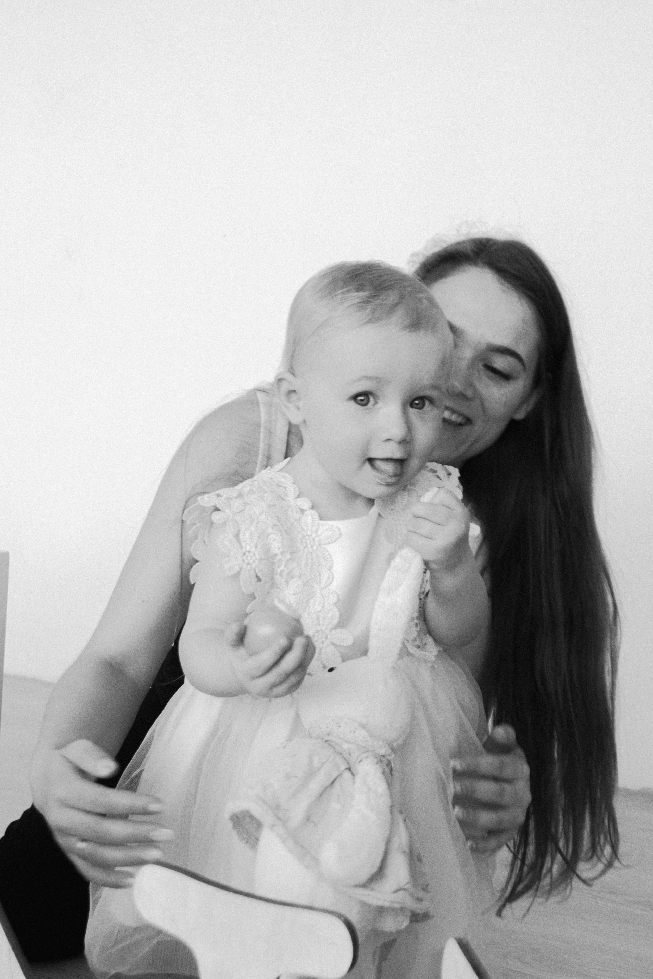 фотография счастливых мамы с дочкой задувших свечку на торте в честь дня рождения