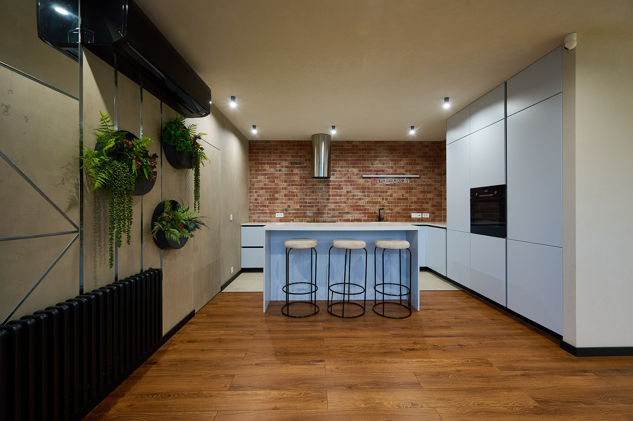 кухонный гарнитур с белыми шкафами удобными высокими стульями и стена в коричневых плитках