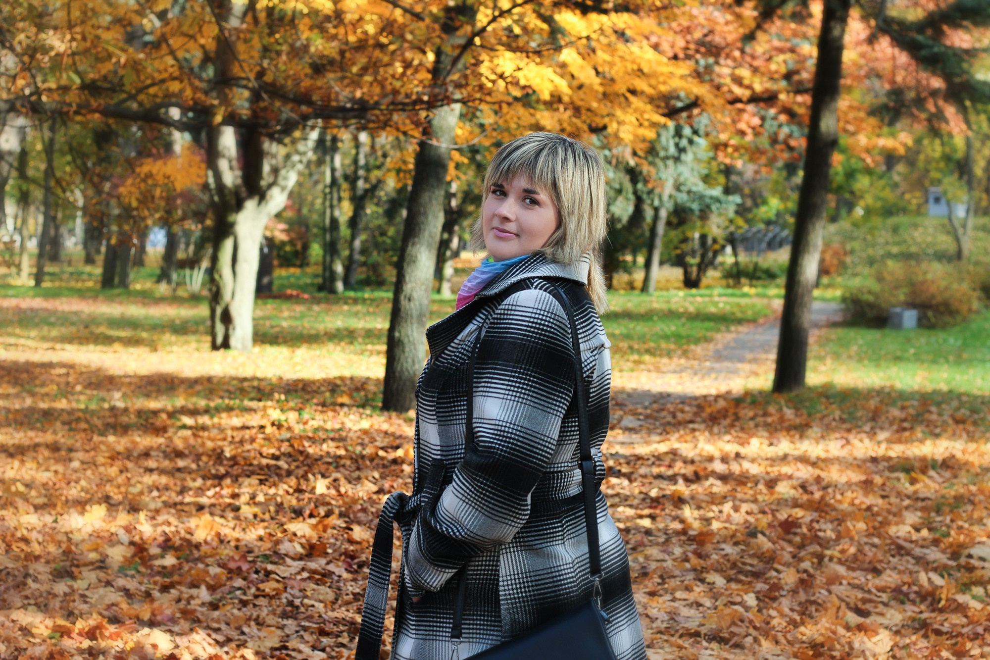 красивая девушка позирует на фоне осенней листвы