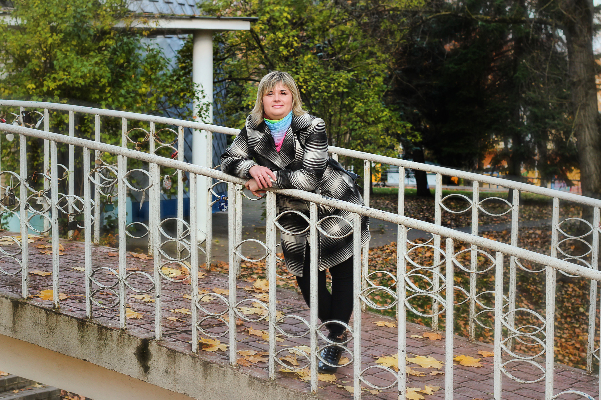 женщина стоит на мосту у красивой ограды