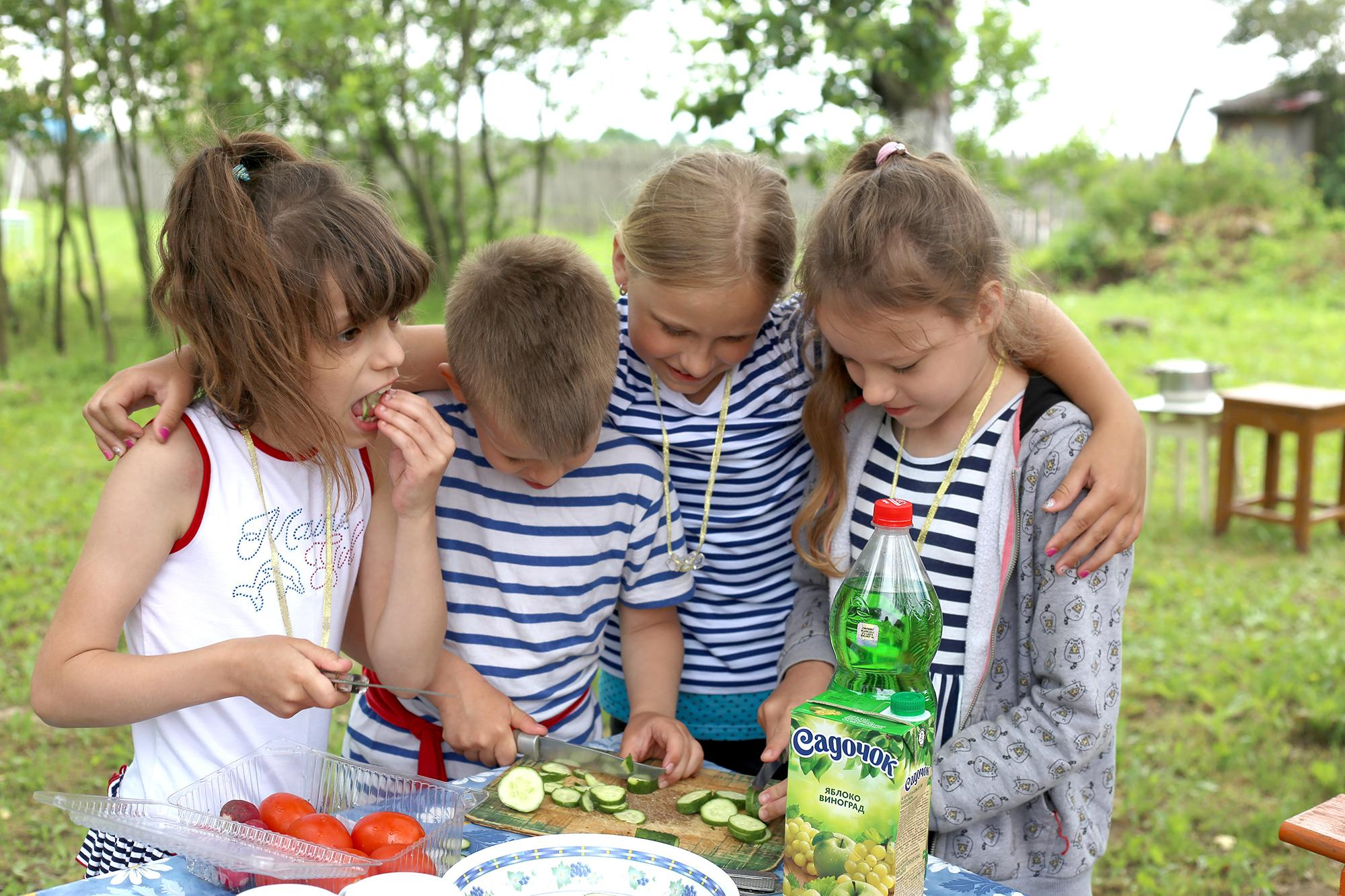 дети готовят салат на свежем воздухе