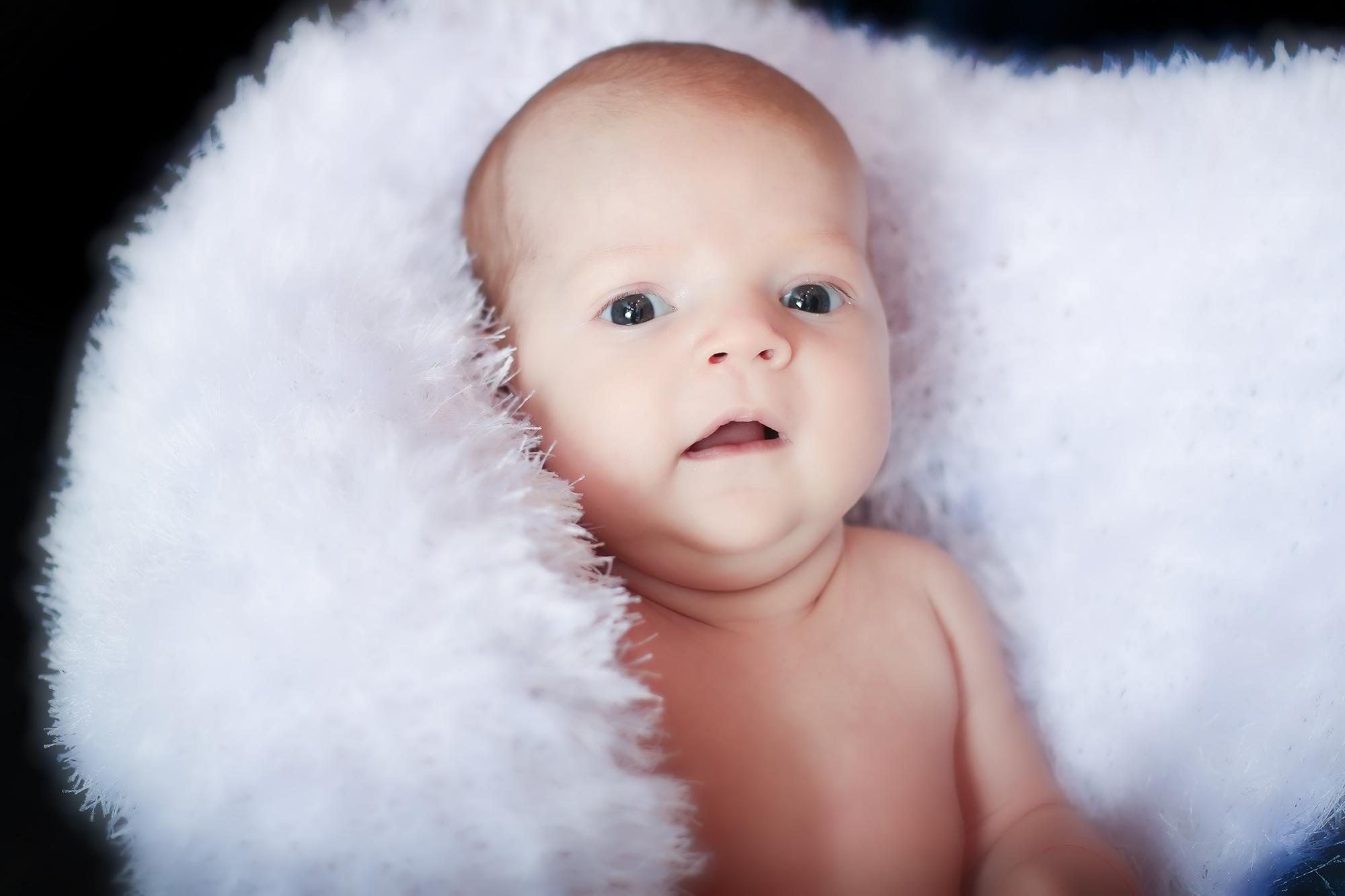 малышка в белом смотрит вперед 