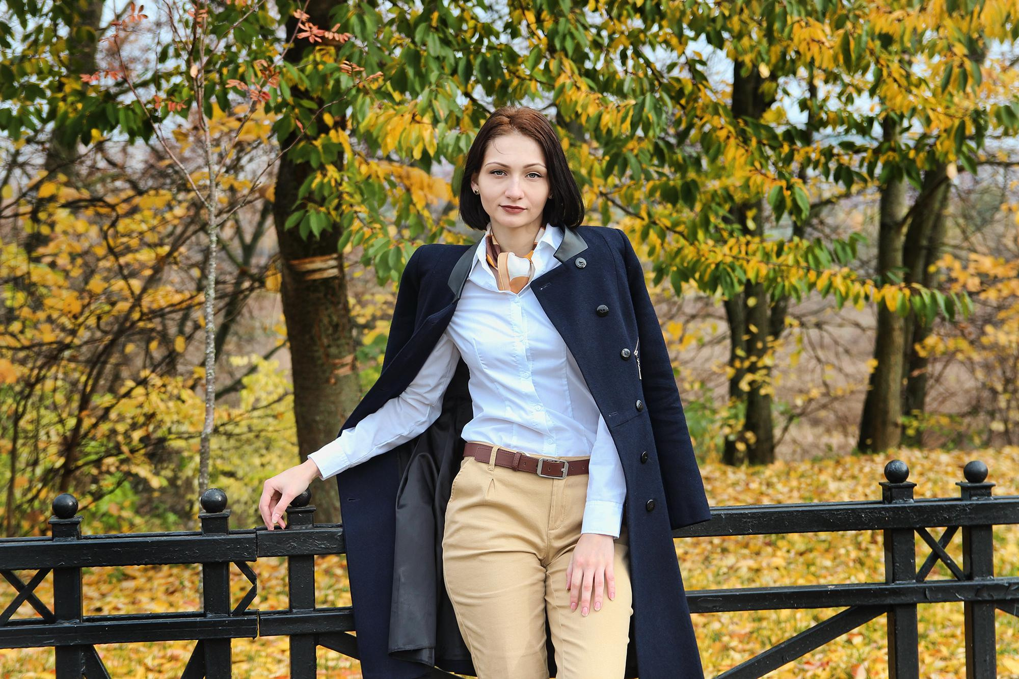 девушка набросила на плечи черное пальто в Минске