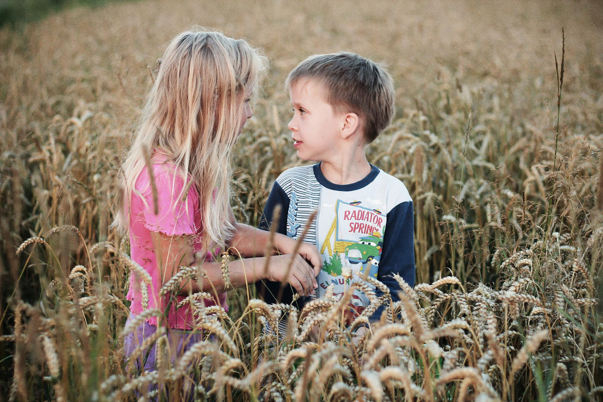 мальчик с девочкой разговаривают в поле в деревне