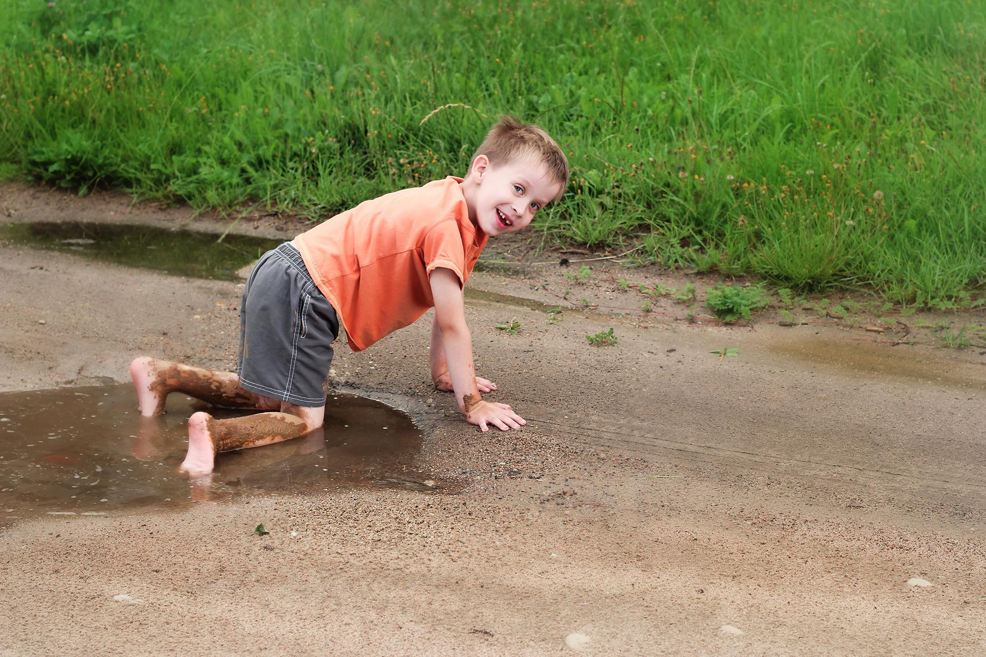 мальчик в оранжевой майке упал в лужу в деревне