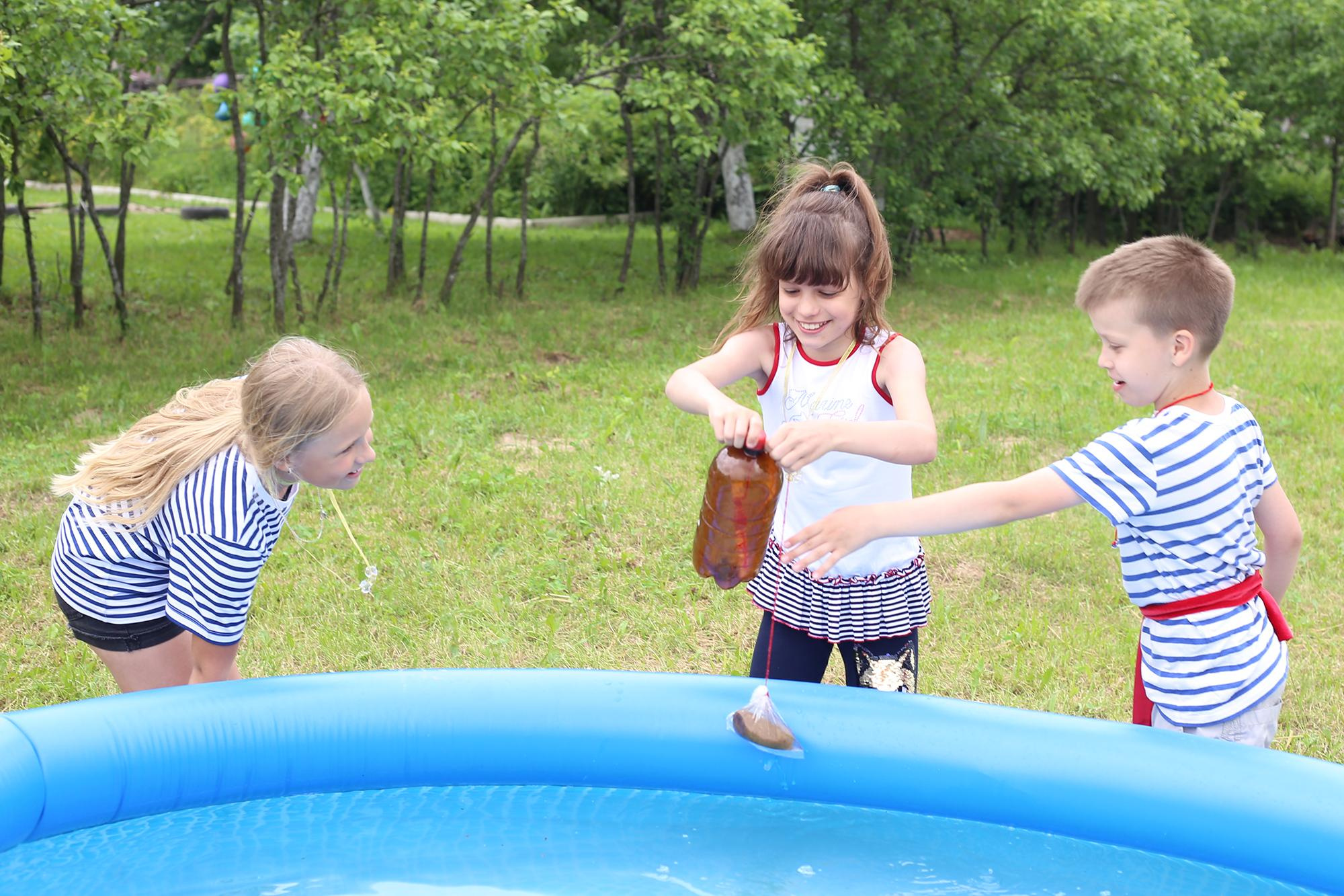 дети вылавливают послание в бутылке в бассейне 