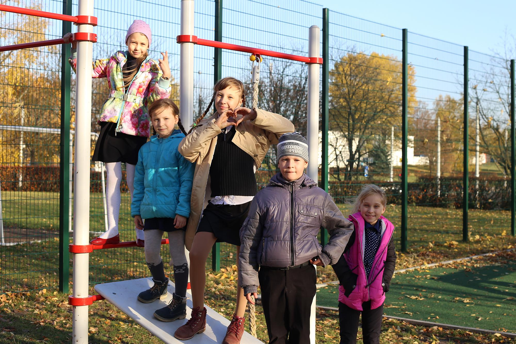 дети осенью стоят на игровой площадке