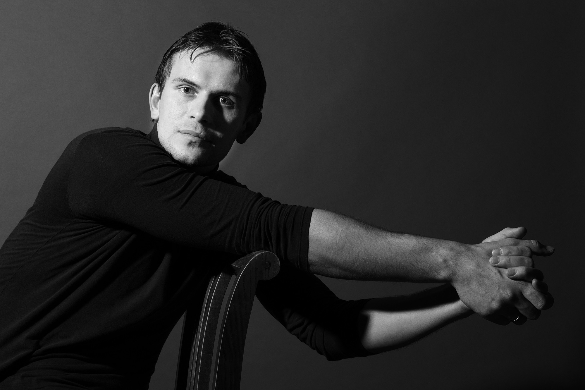 молодой мужчина позирует на черно-белом фото