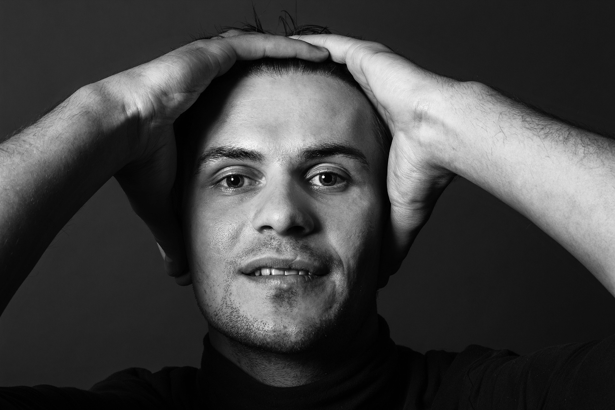 молодой человек держится руками за голову 