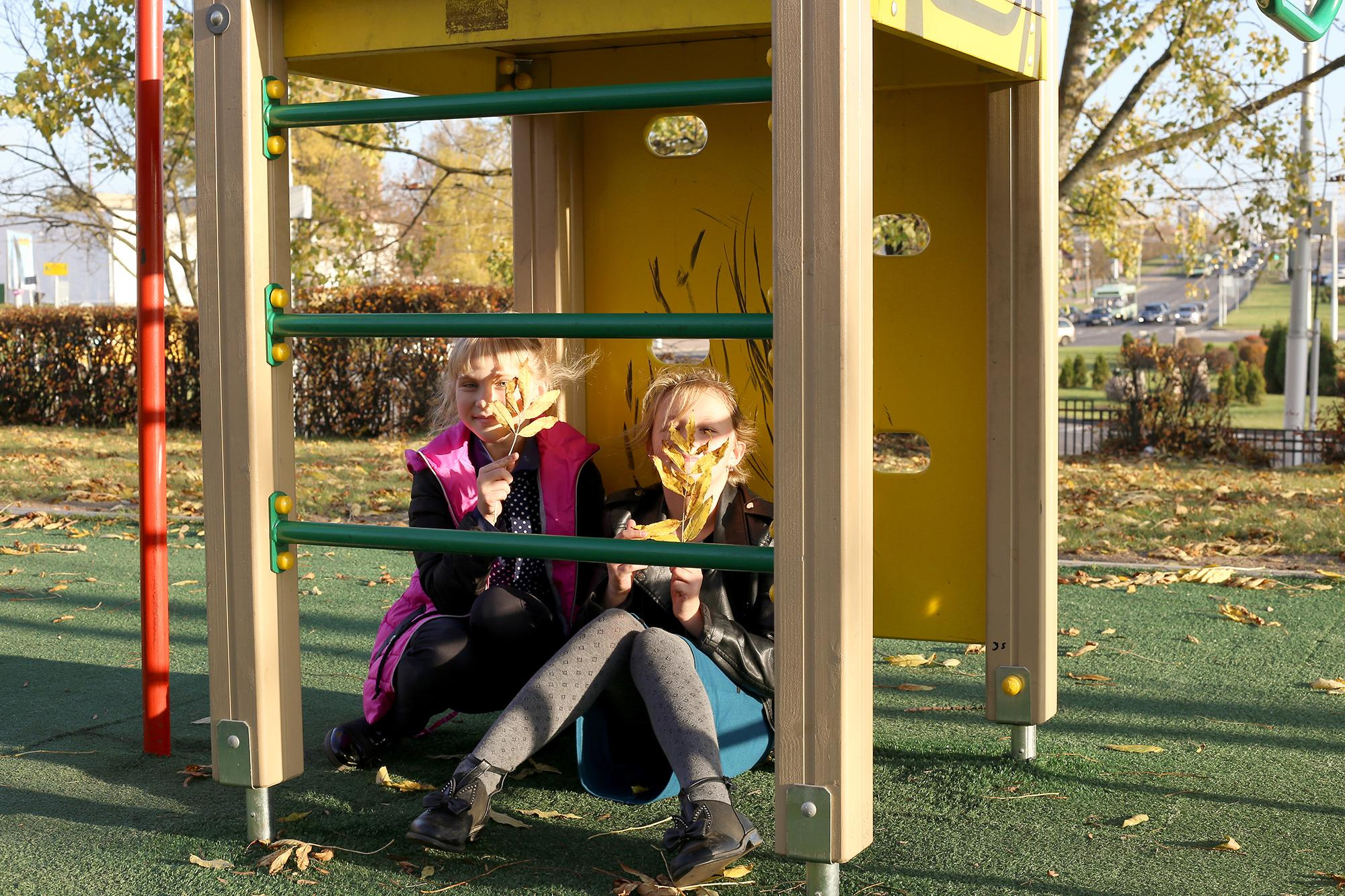 девочки спрятались под горкой на игровой площадке