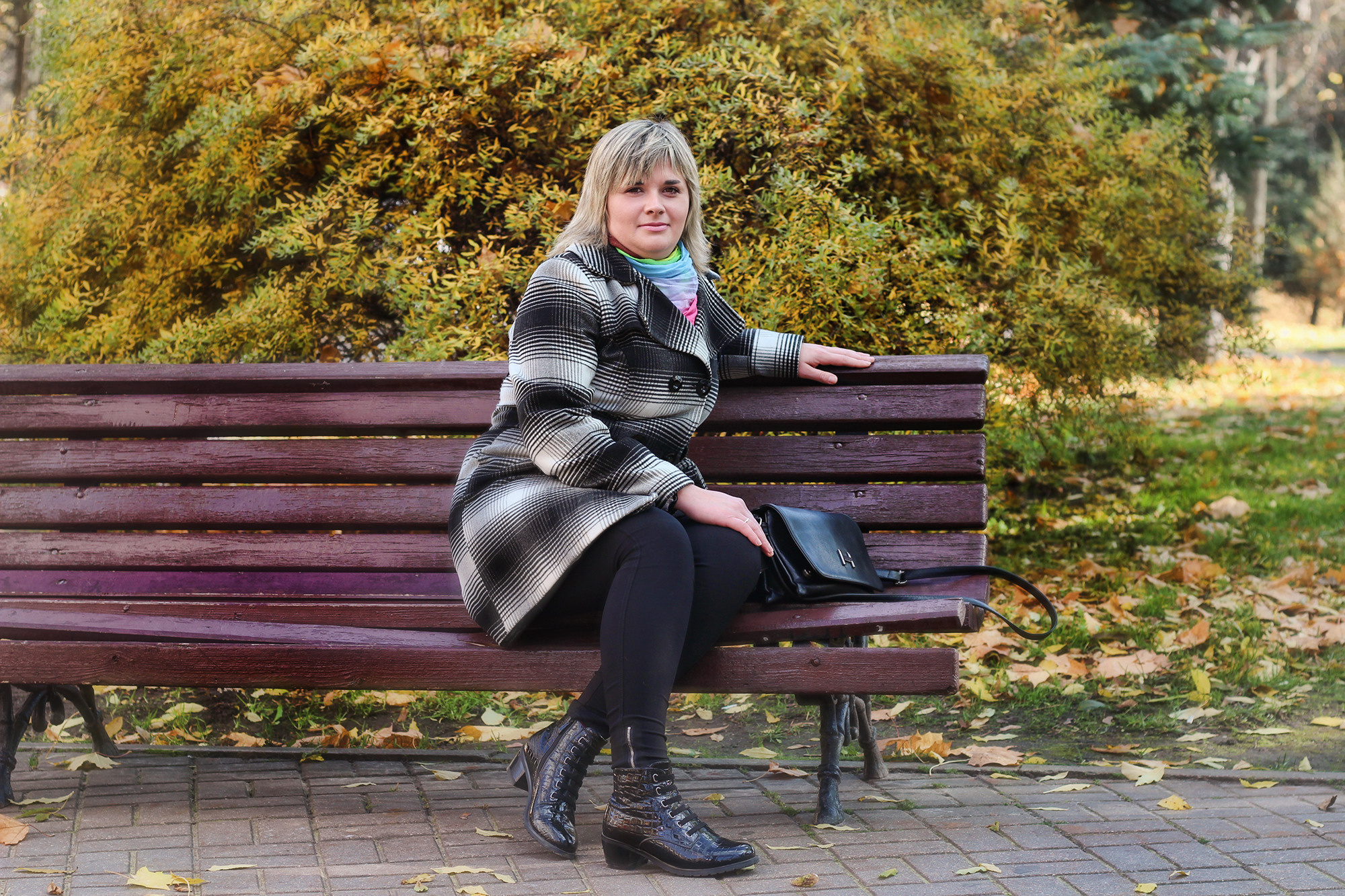 женщина на деревянной скамейке в осеннем парке