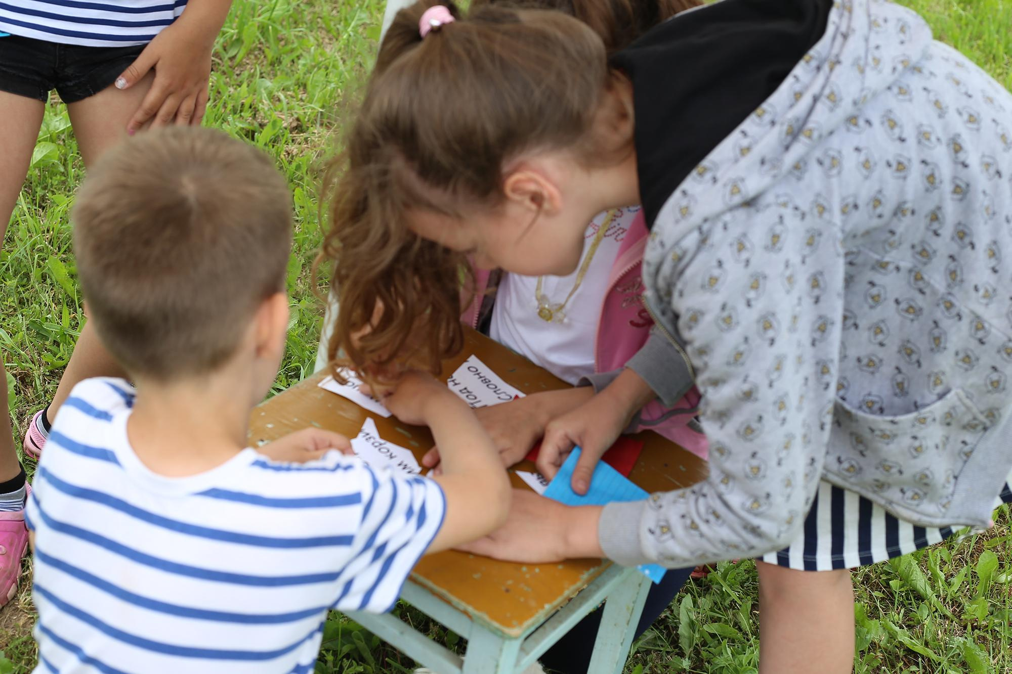 дети разгадывают ребус на природе