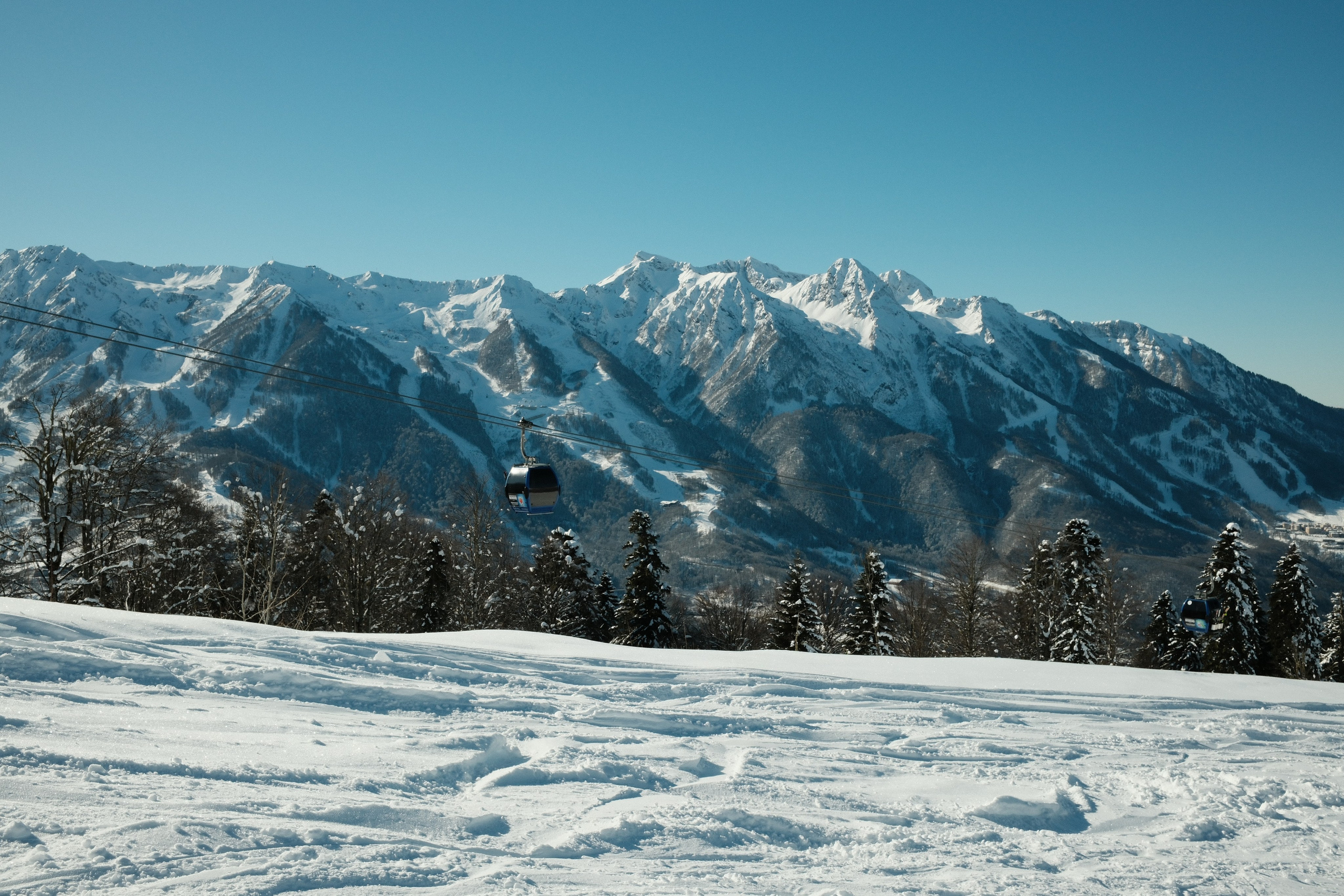 Кабина горнолыжного подъемника на фоне Кавказских гор.