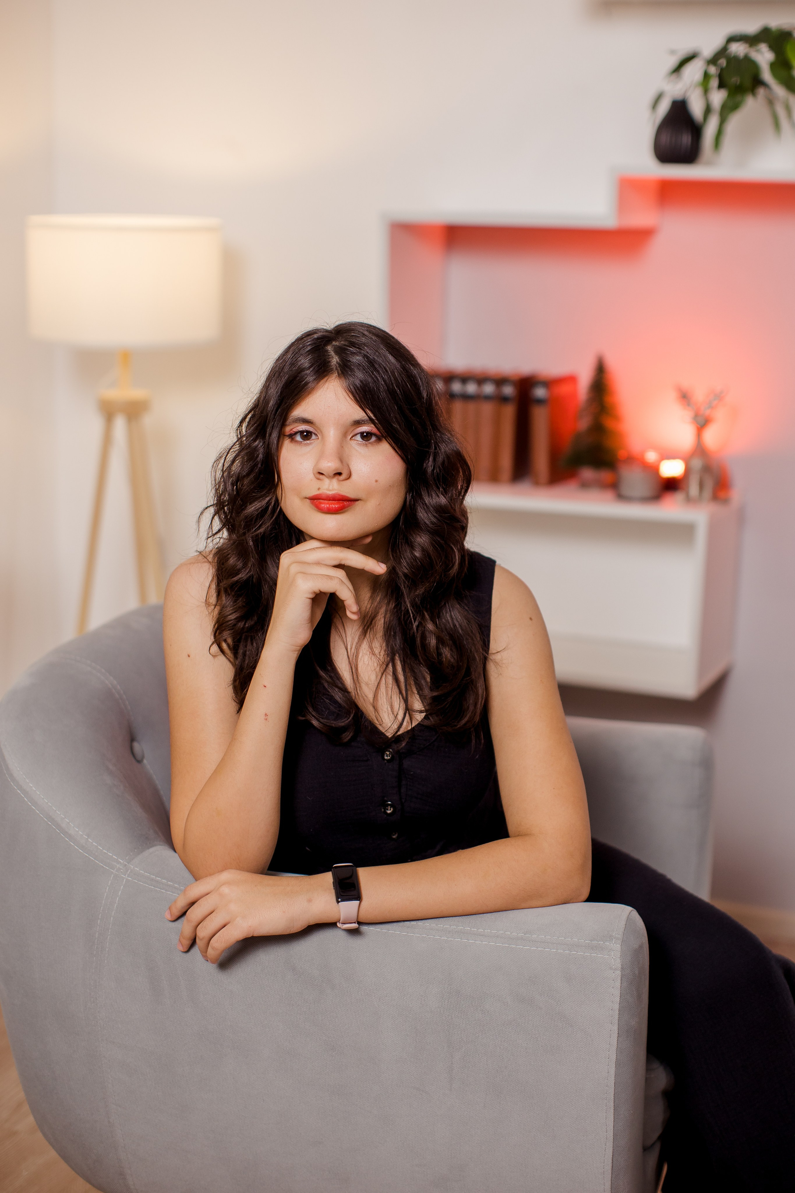 Девушка сидит в кресле в фотостудии