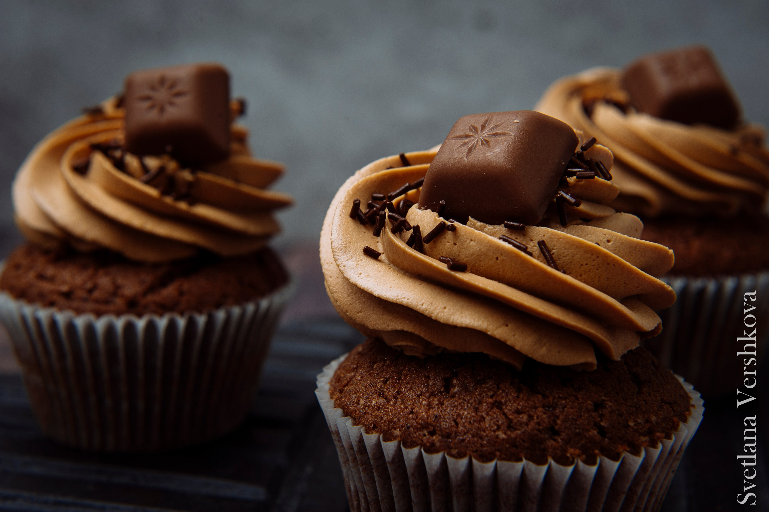 Шоколадные капкейки– насыщенный шоколадный бисквит. В сердцевине капкейка может быть начинка на Ваш вкус и усмотрение (фруктово-ягодные начинки, соленая карамель). Шапочка выполнена из нежнейшего творожного сыра (крем-чиза) с добавлением сливочного масла и бельгийского (темного или молочного) шоколада, либо натуральных взбитых сливок, сгущенного молока (крем также оговаривается исходя из предпочтений заказчика).