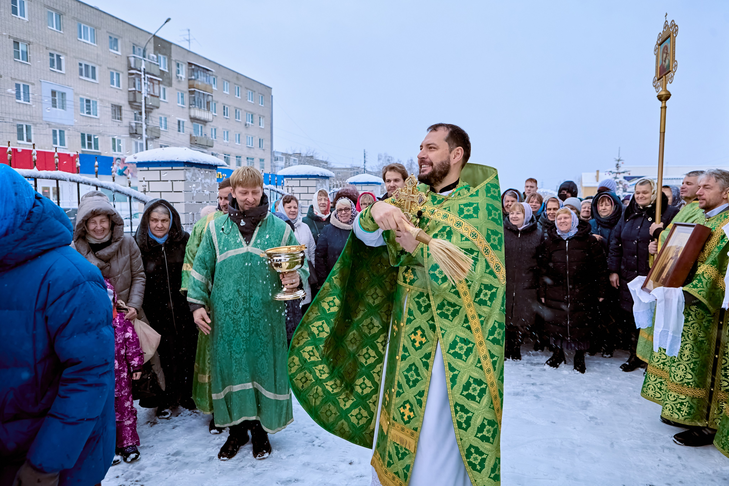 Священник окропляет святой водой участников Крестного хода