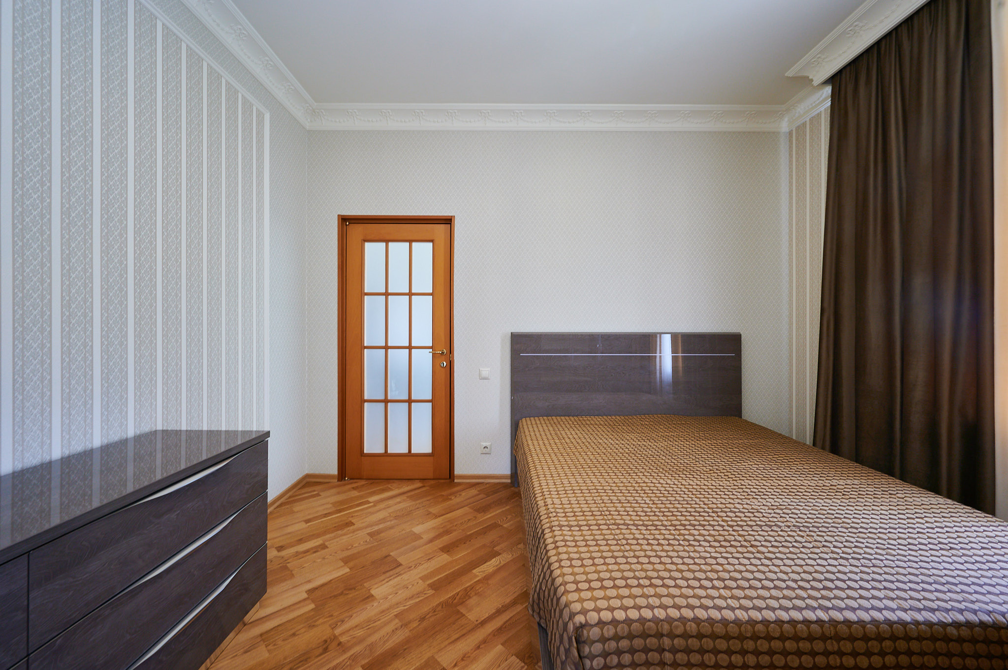 комната белые стены коричневая кровать коричневая тумбочка 