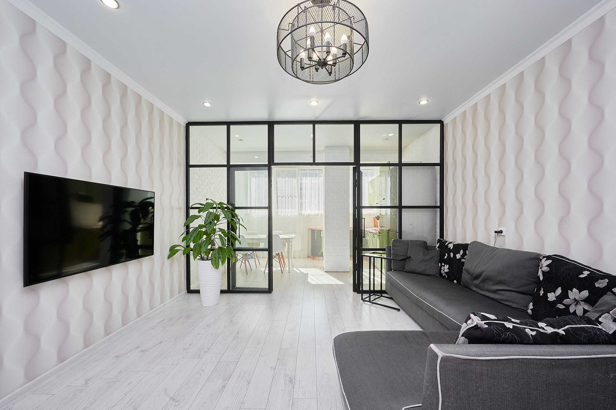 гостиная черный диван светлые обои 