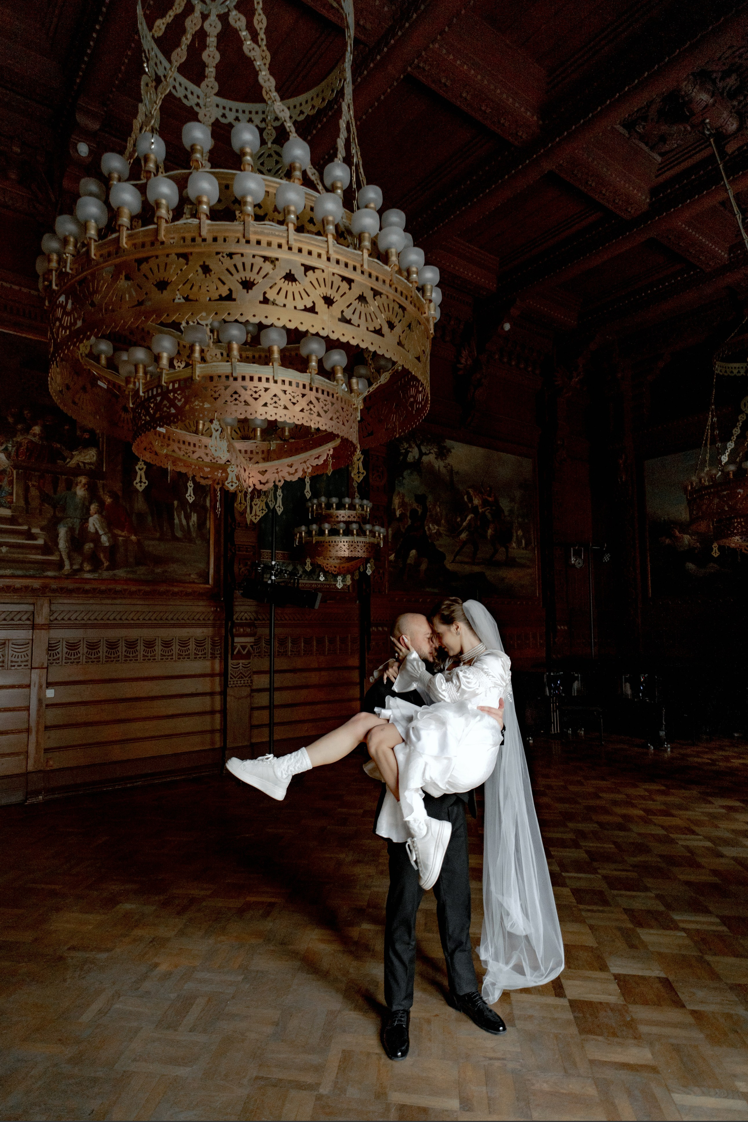 жених держит на руках невесту во Дворце Великого Князя Владимира в Дубовом зале