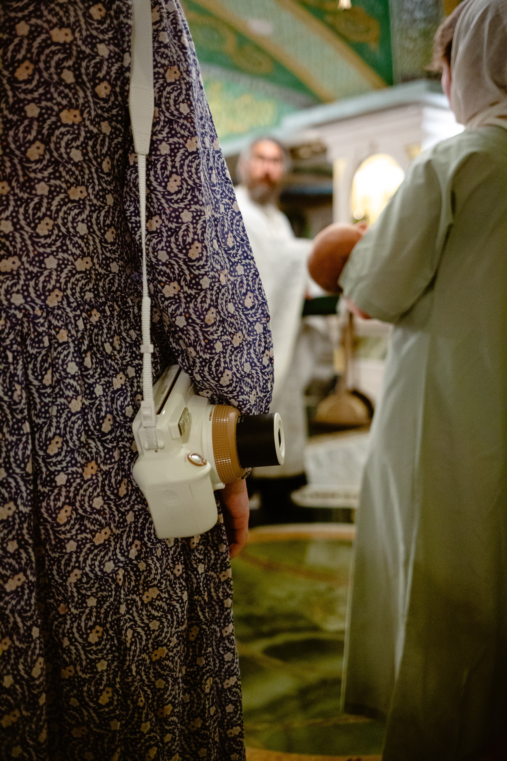 Фотосъемка крещения в сретенском монастыре. Крестная держит на руках младенца, который будет креститься.