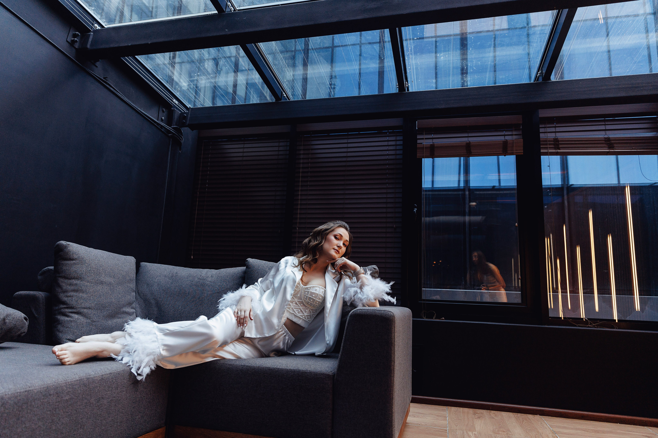 Невеста лежит на диване во время утренней фотосессии в отеле Мариотт в Воронеже