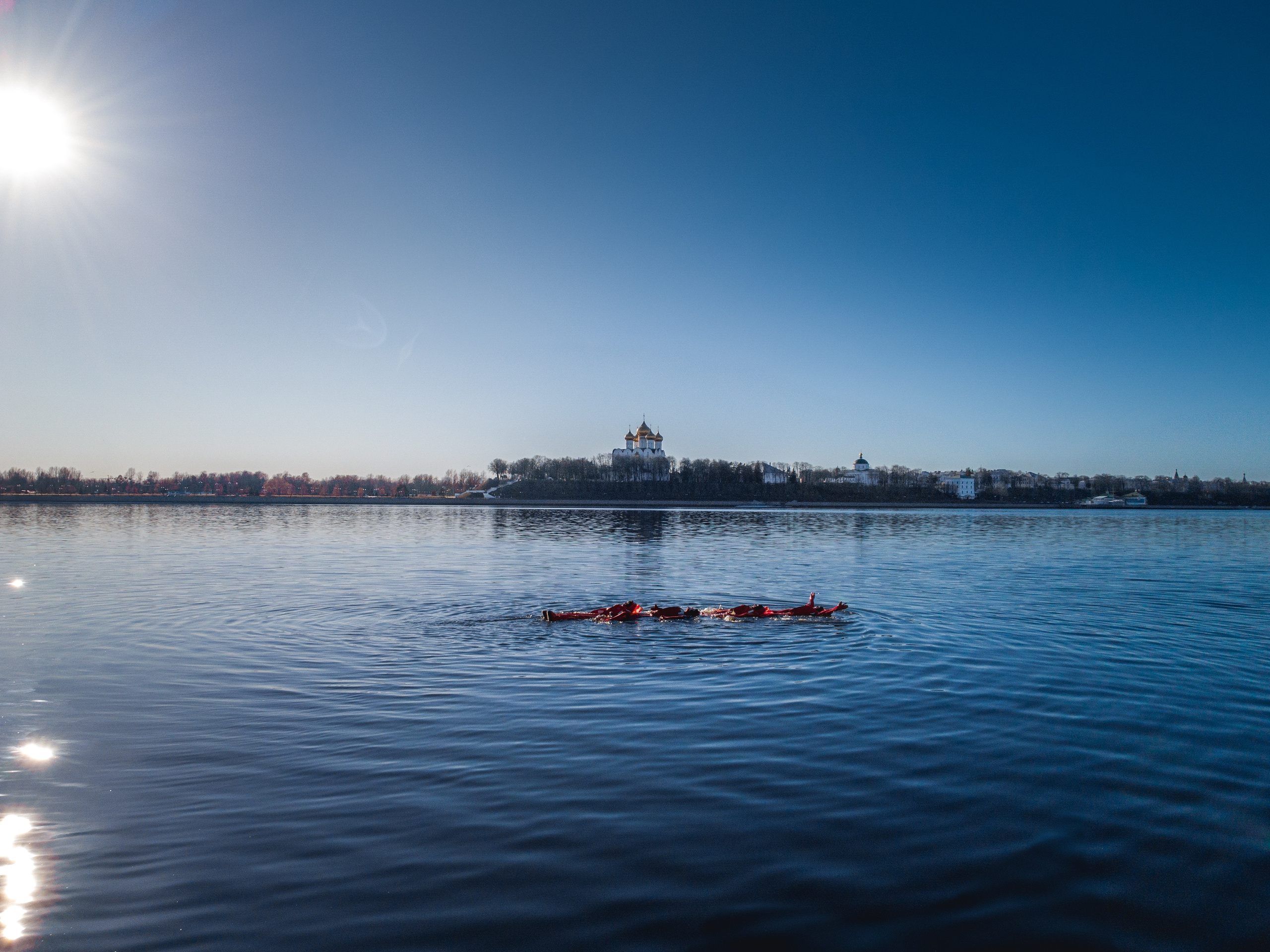 Люди купаются среди льдин, в спасательных оранжевых термо костюмах, айс флоатинг Ярославль