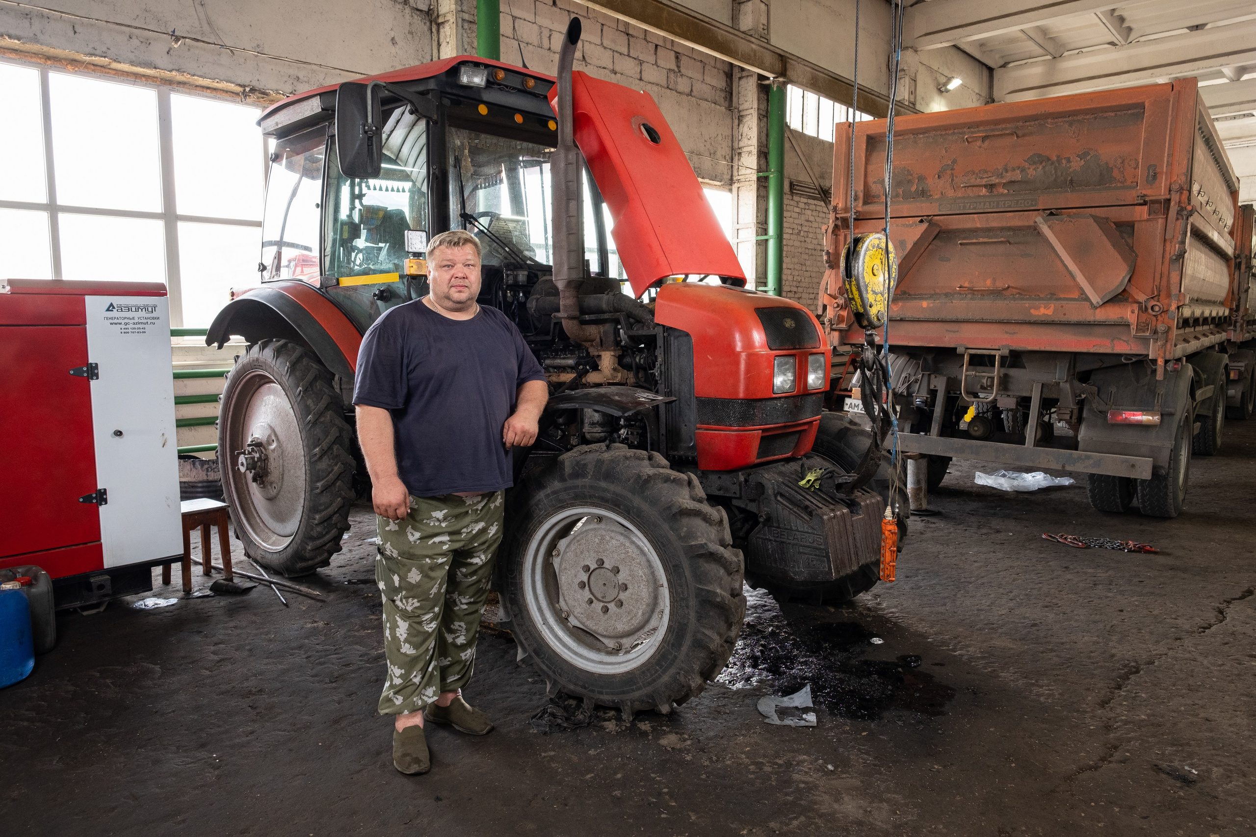 Автомеханик на фоне красного трактора
