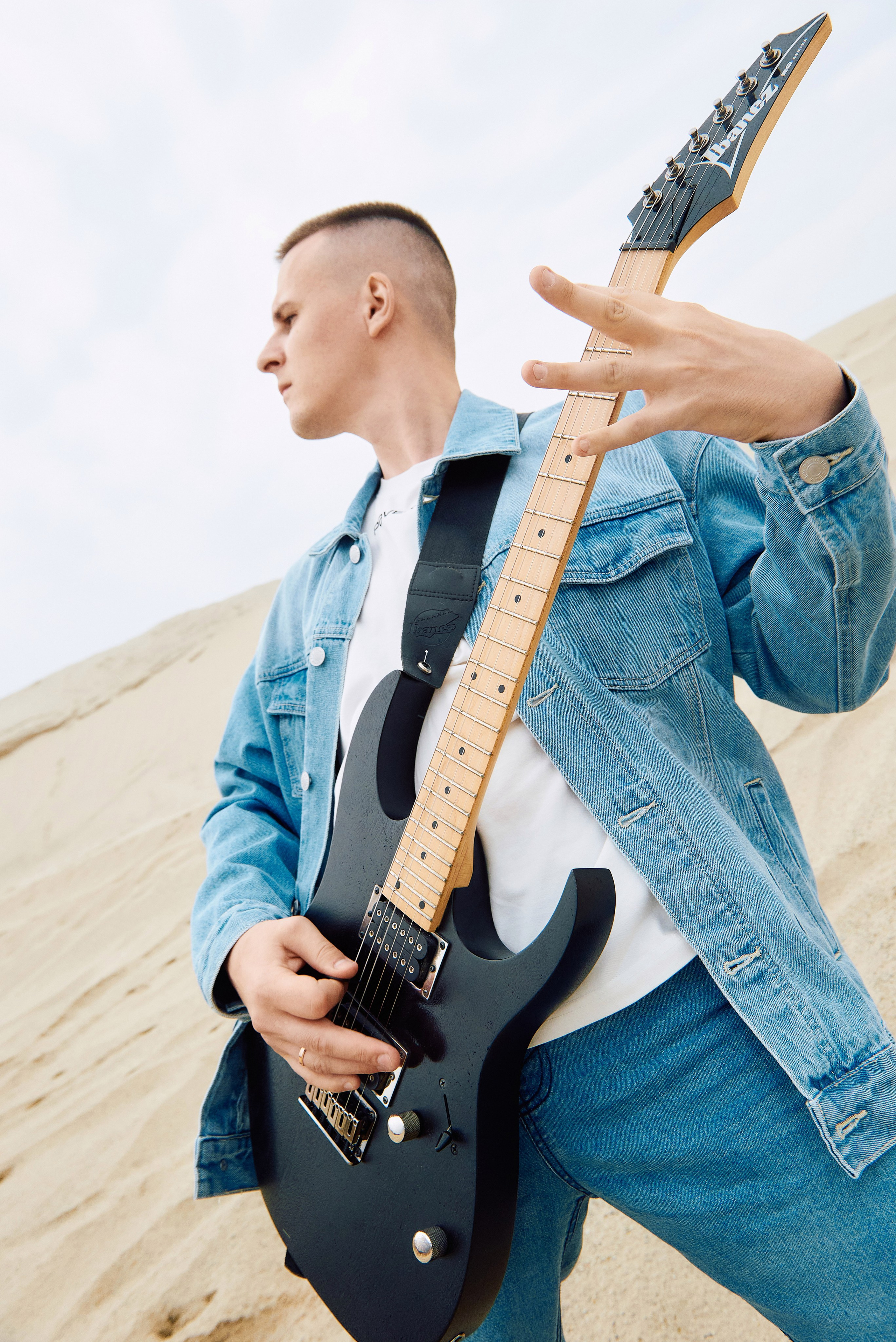 Парень играет на гитаре в пустыне