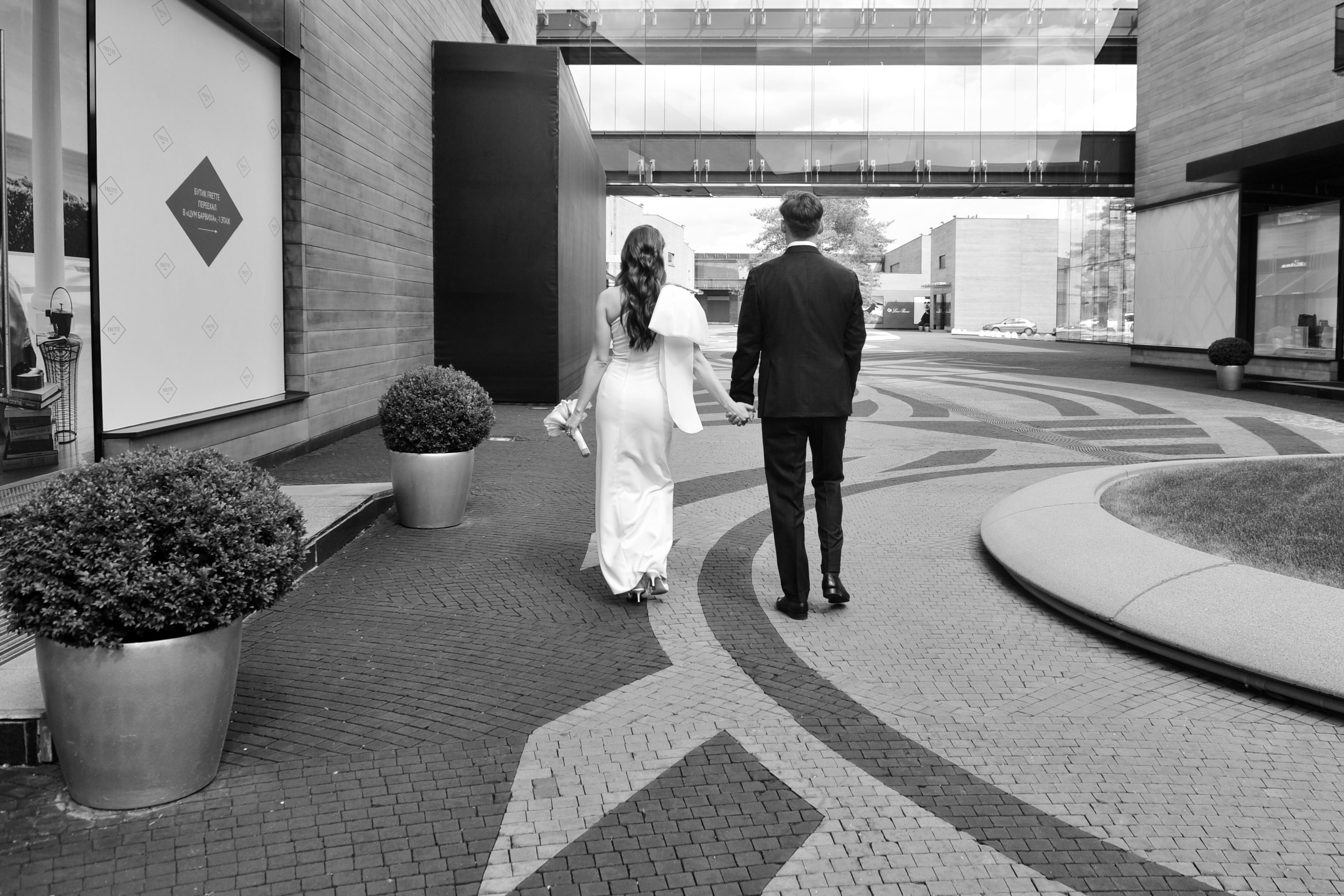 Свадьба в ЗАГСе Барвиха Luxury Village летом, вид молодоженов со спины, чёрно-белая фотография