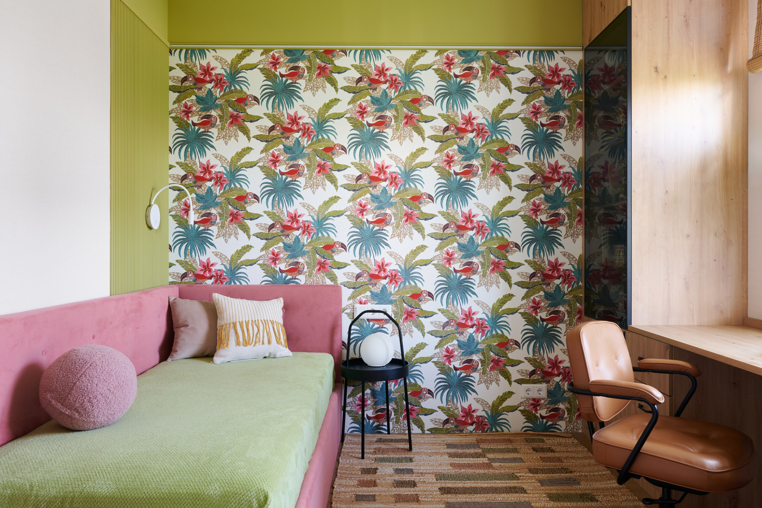 Спальня с цветочными обоями, зелёным покрывалом и креслом