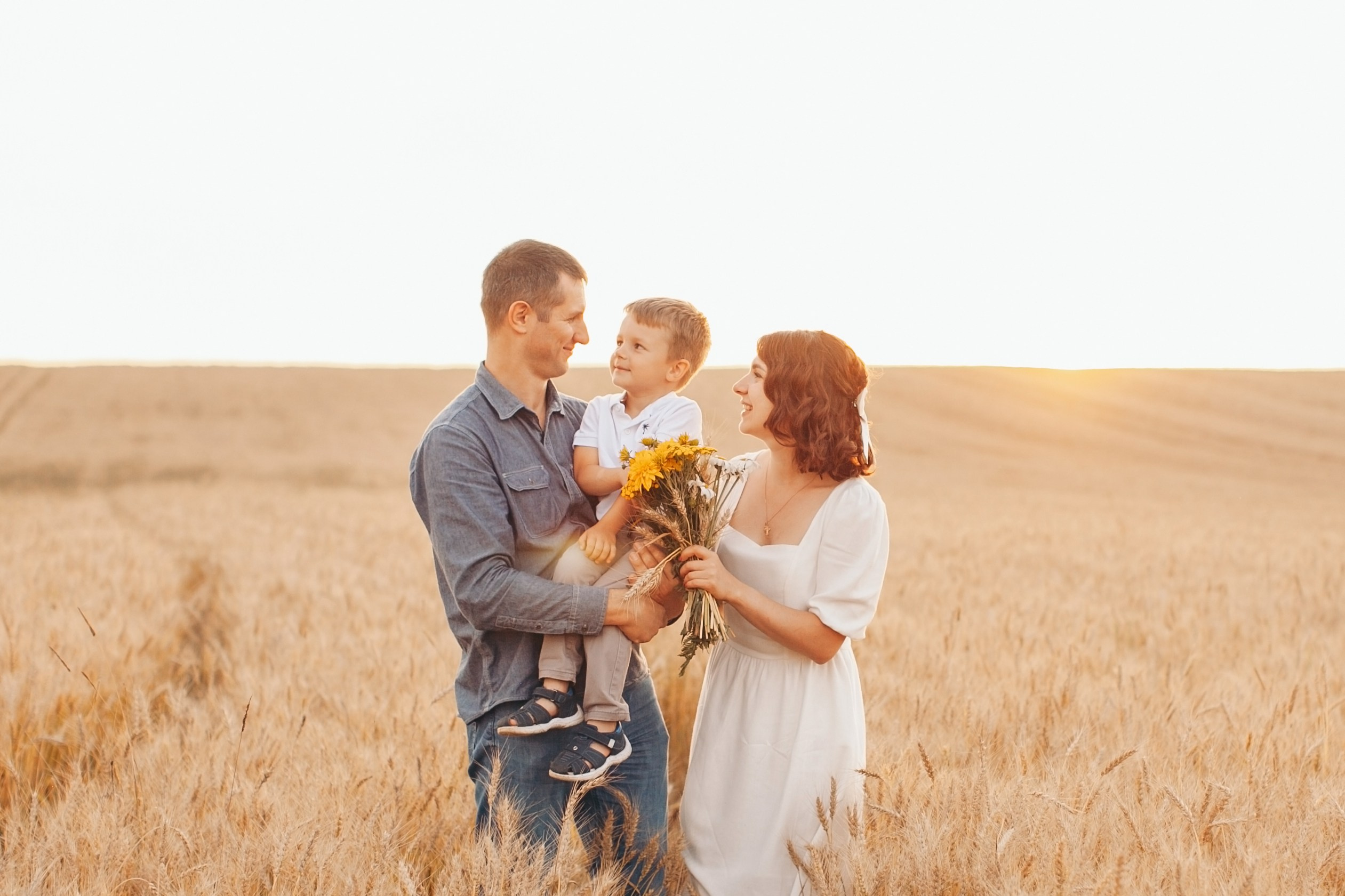 идеальная семья на фотосессии в закате на фоне пшеницы
