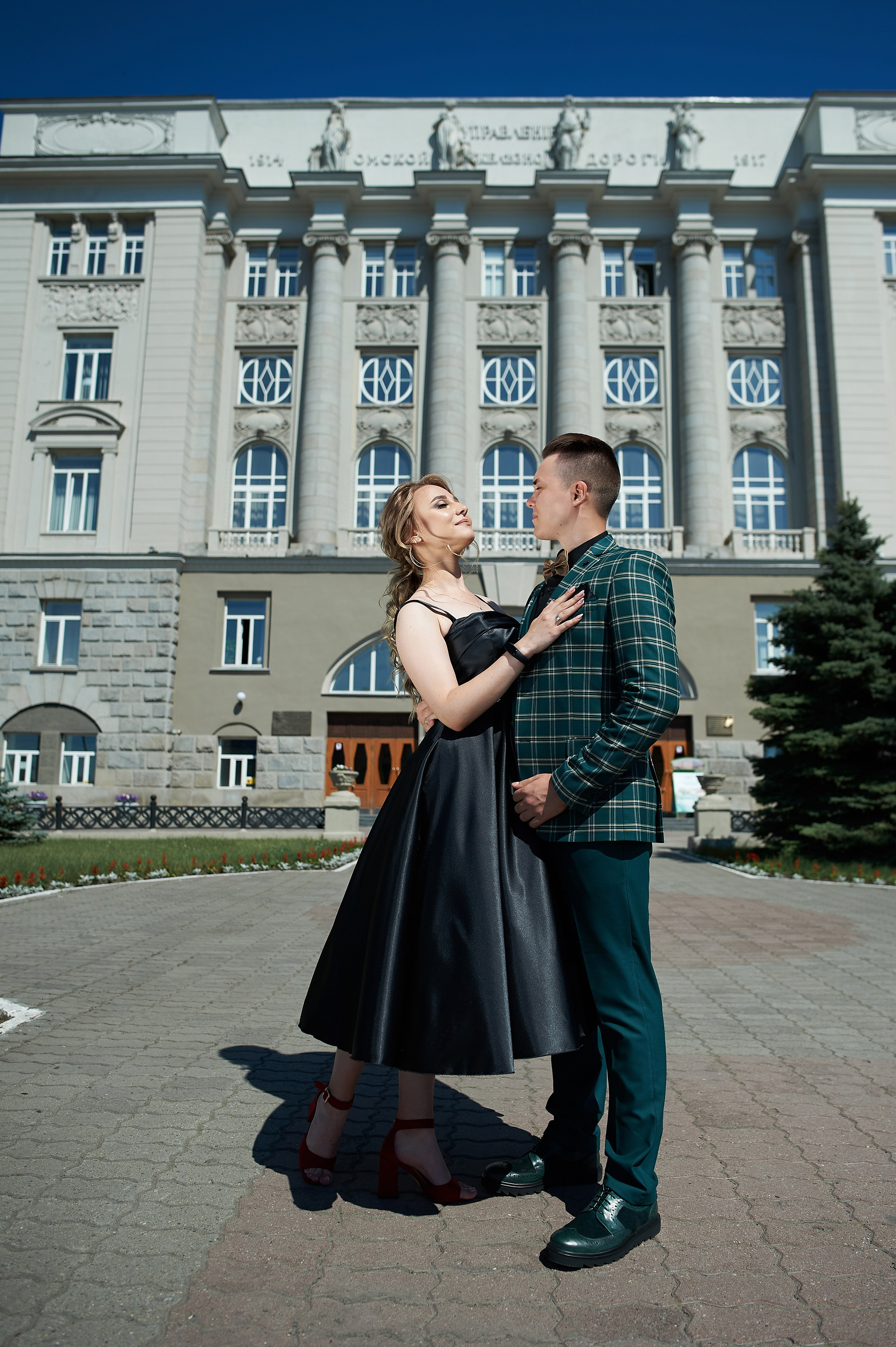 Стильное фото влюбленных на фоне красивого здания.