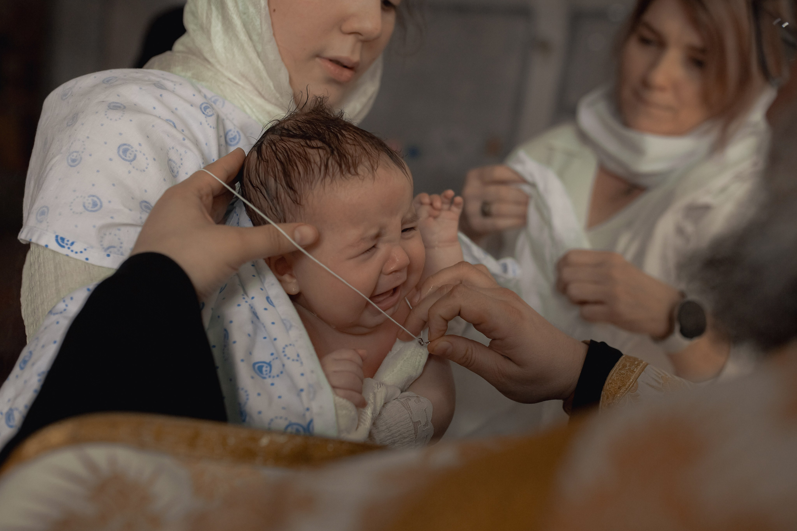 на ребенка надевают крестик после совершения крещения в Ташкенте