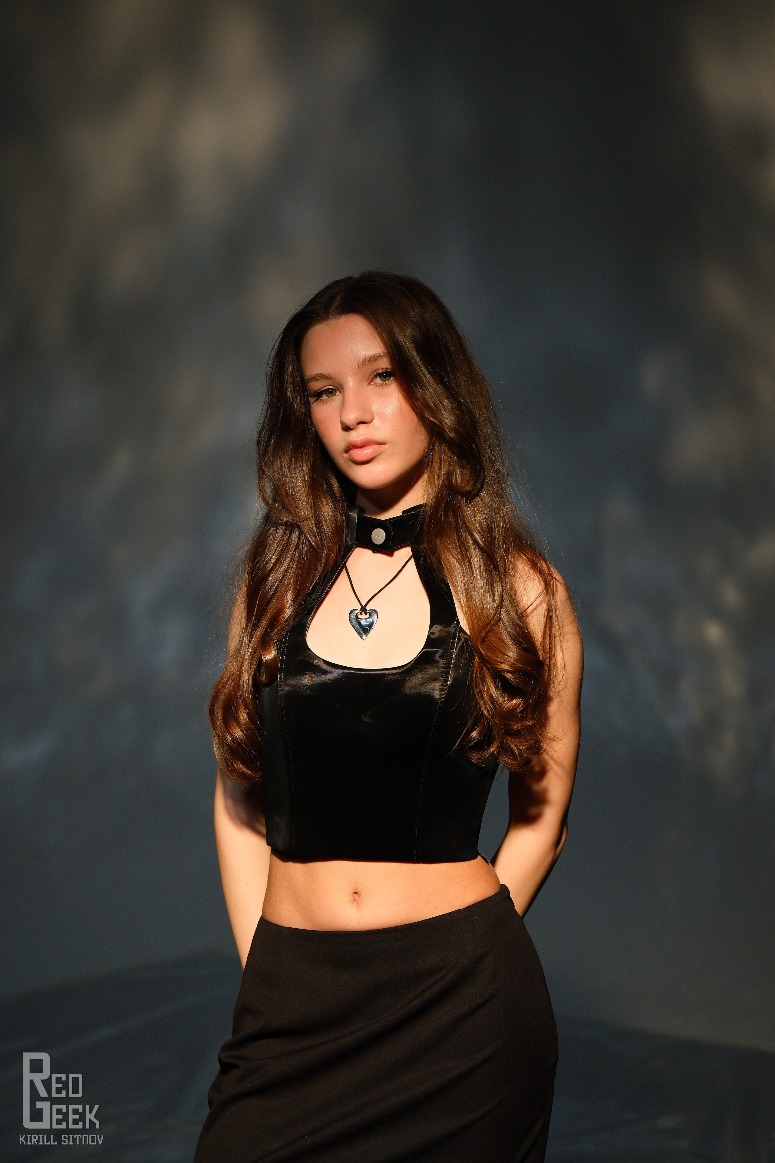 Строгий студийный портрет стройной девушки, смотрящей прямо в камеру.