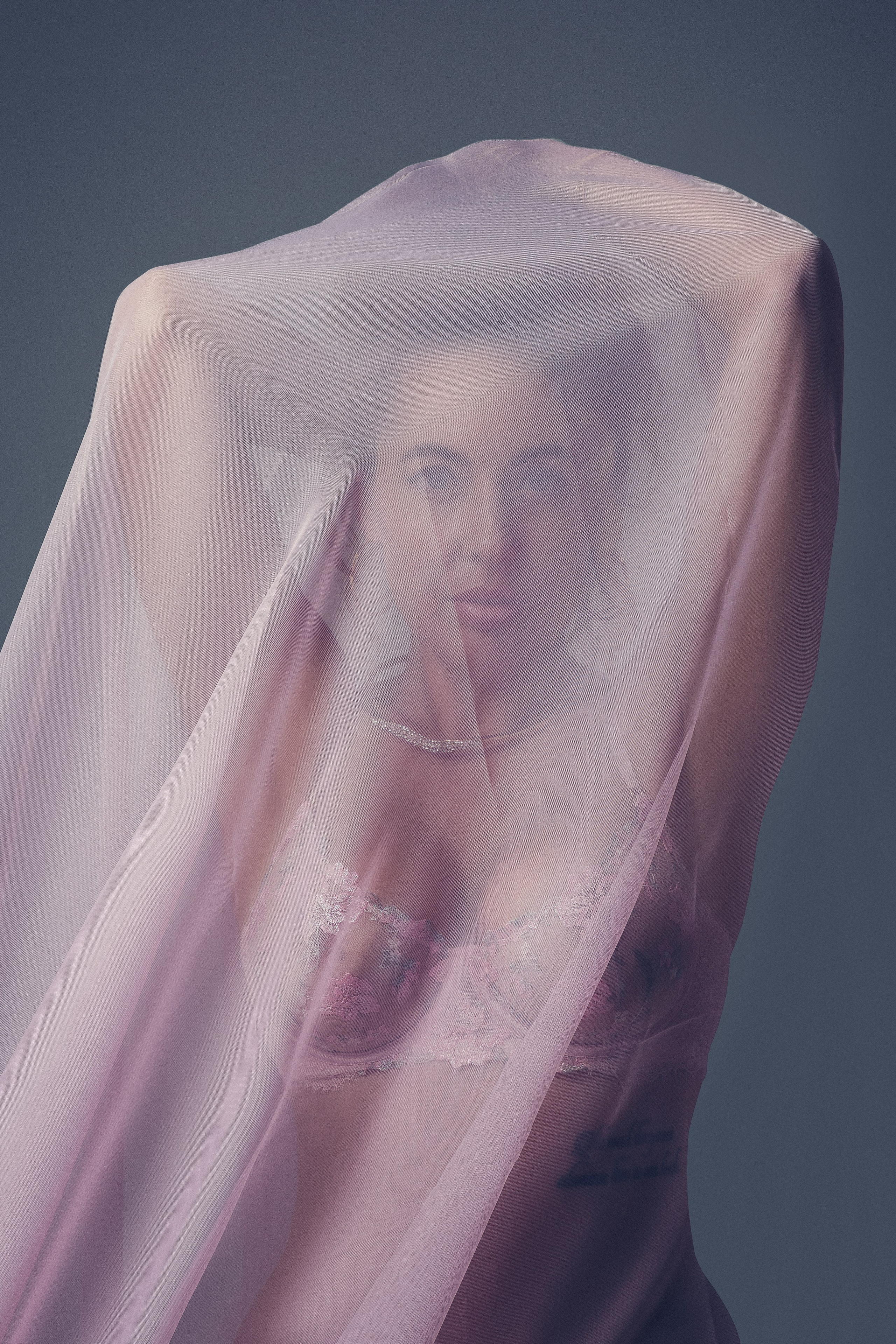 Фотосессия девушки в студии с розовой тканью