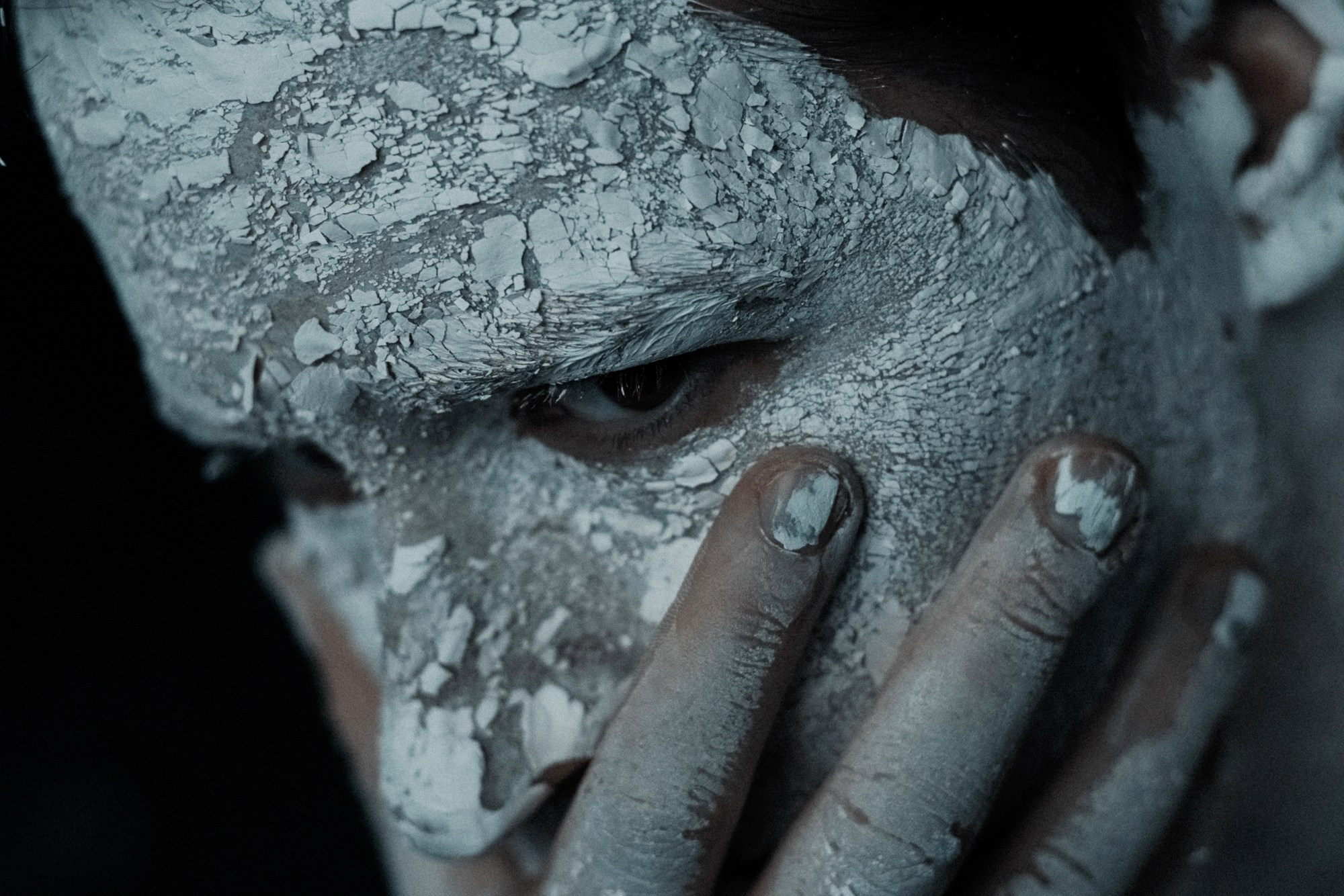 Фактурный портрет мужчины с белой глиной на лице, художественная съемка, работа с материалами и светом