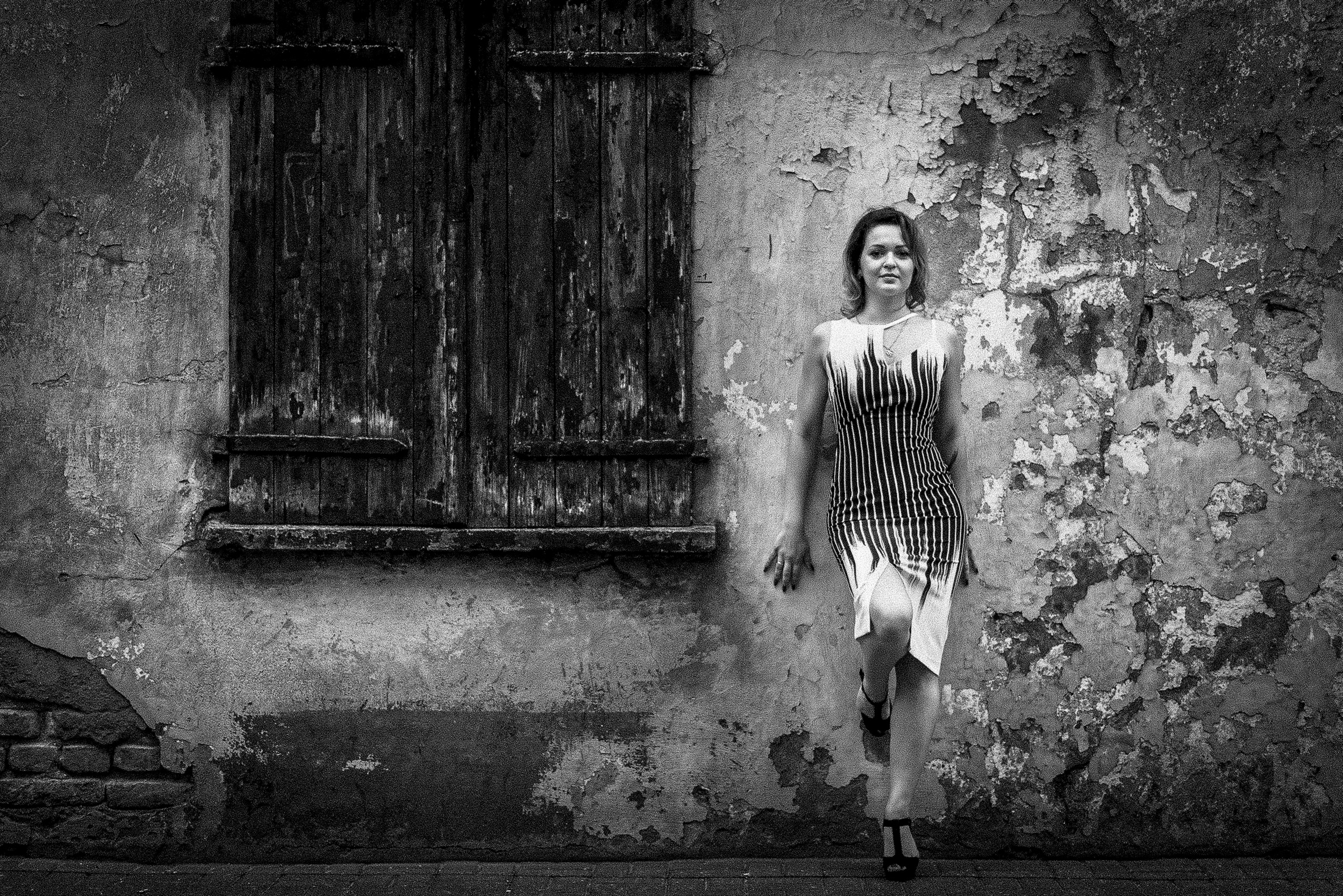 Портрет девушки в полный рост у старой стены