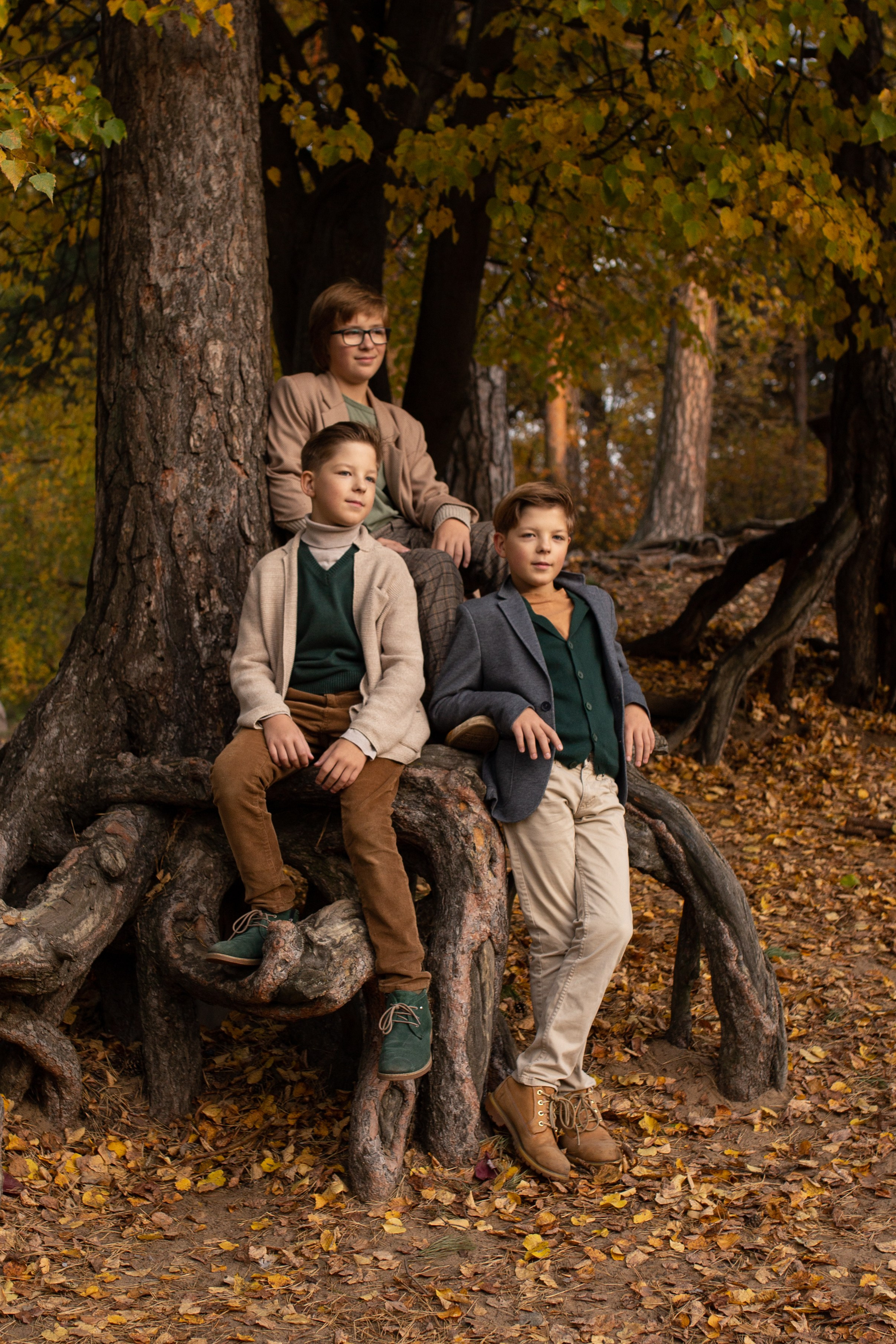 Мальчики в парке у дерева осенью 