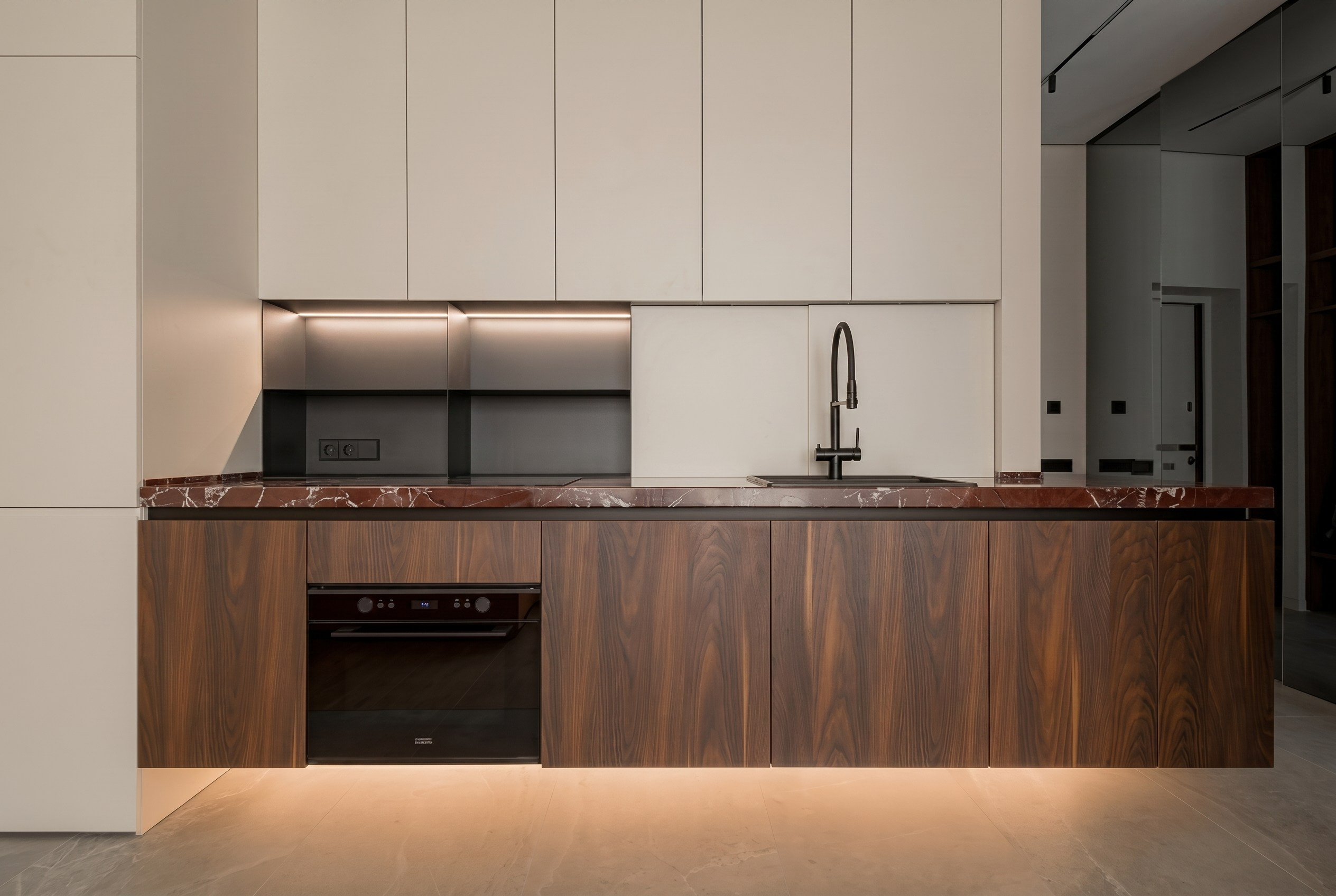 Линейная кухня в стиле теплый минимализм: парящие фасады из шпона, каменная столешница и встроенная подсветка, дизайнер Валерия Котович.