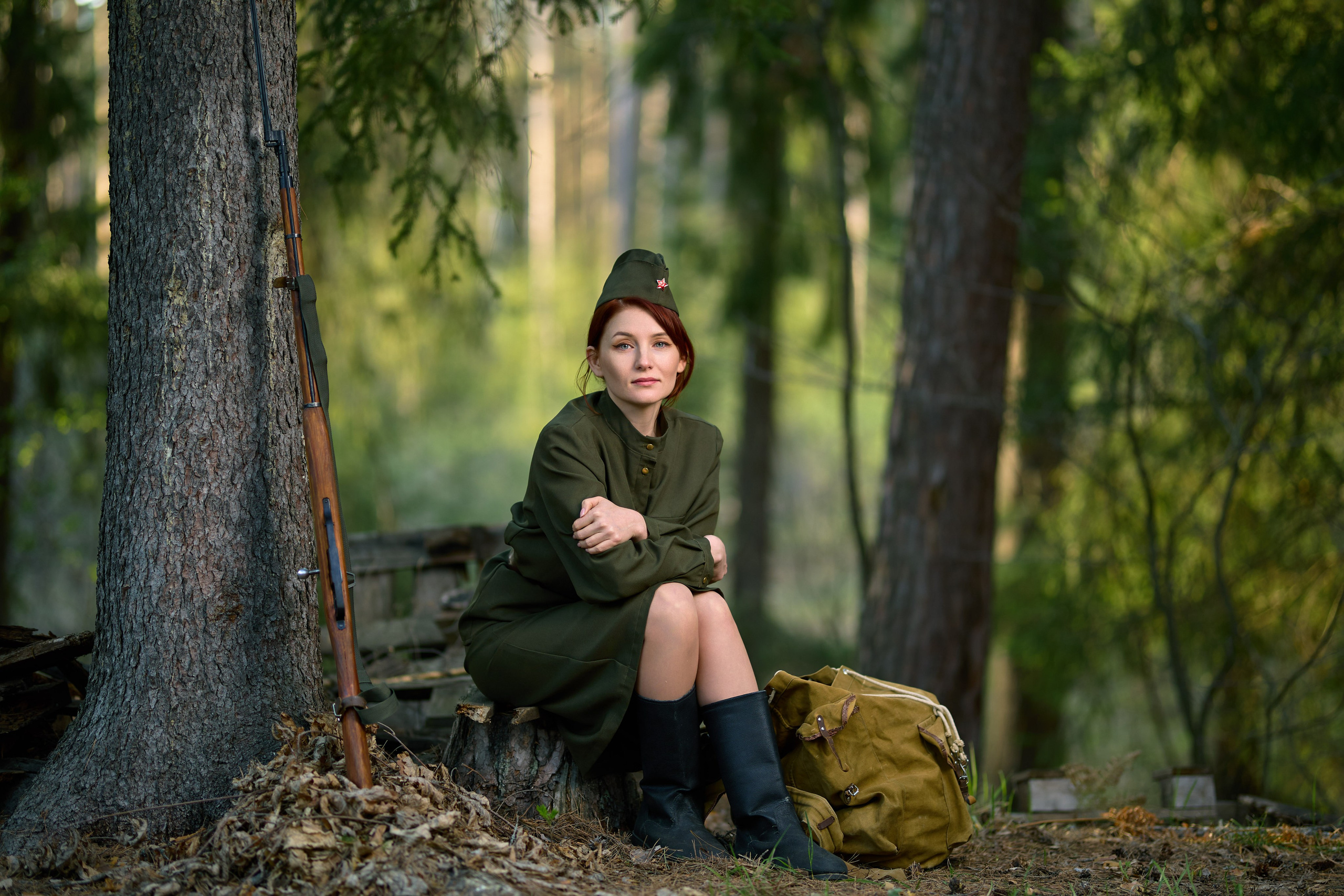 тематическая фотосессия на военную тему, девушка сидит с винтовкой в лесу