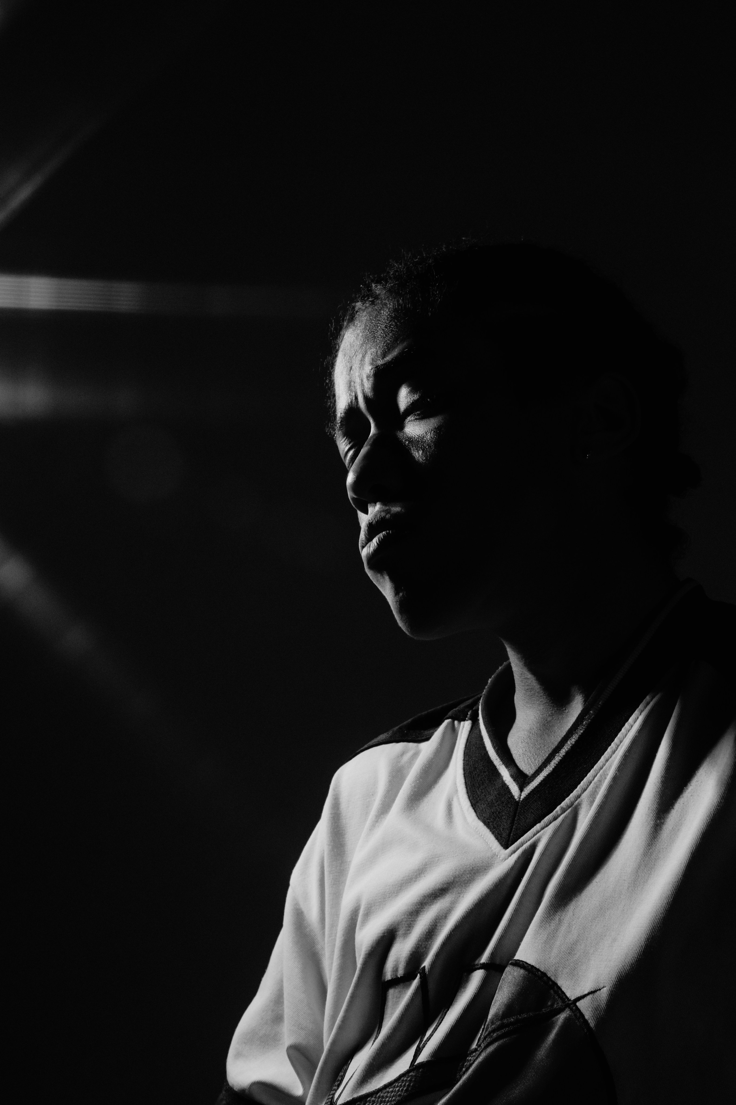 Черно-белый портрет мужчины в спортивной футболке с контровым светом на лице