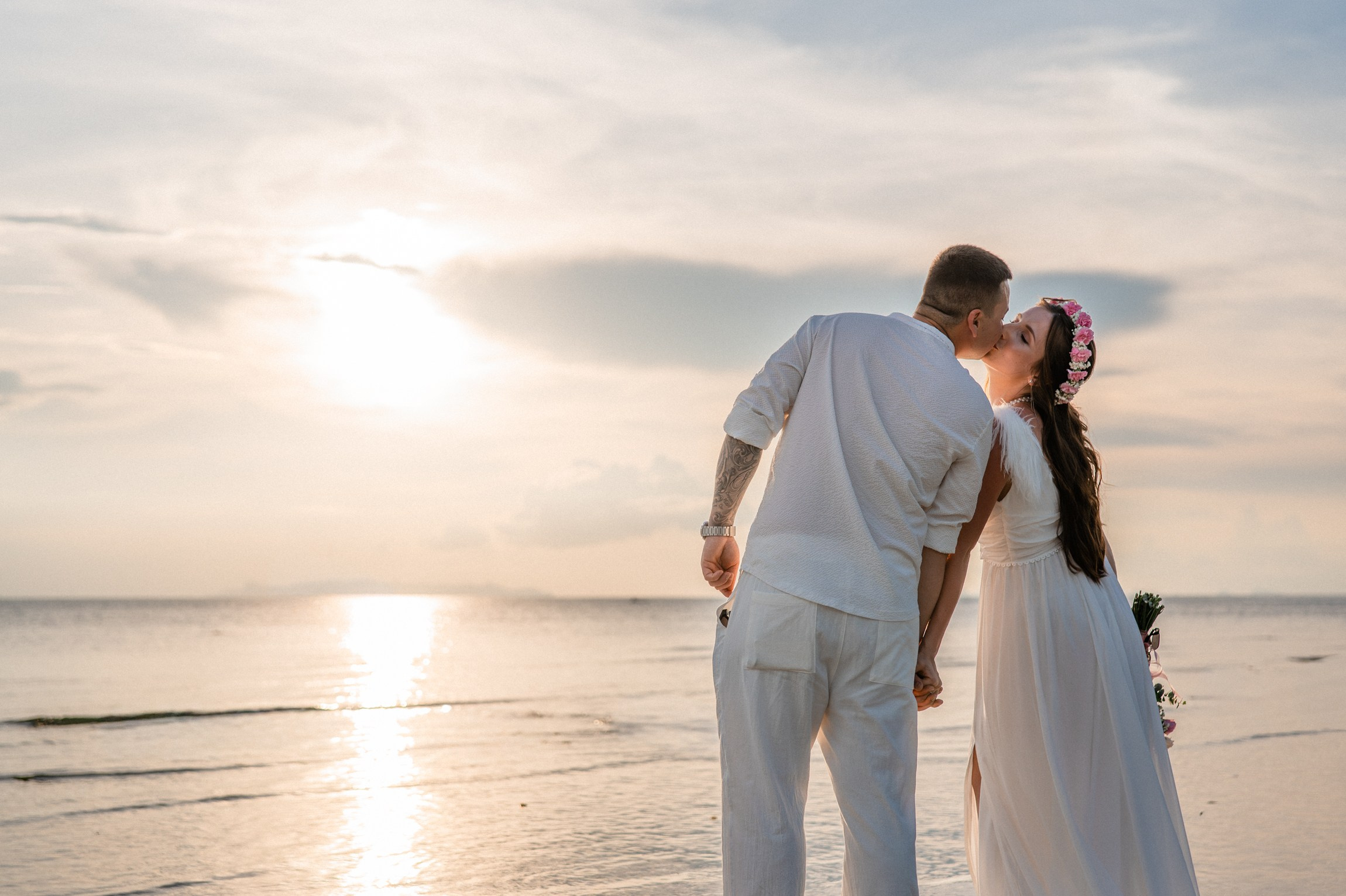 Bride and groom exchanging vows on a private sunset beach