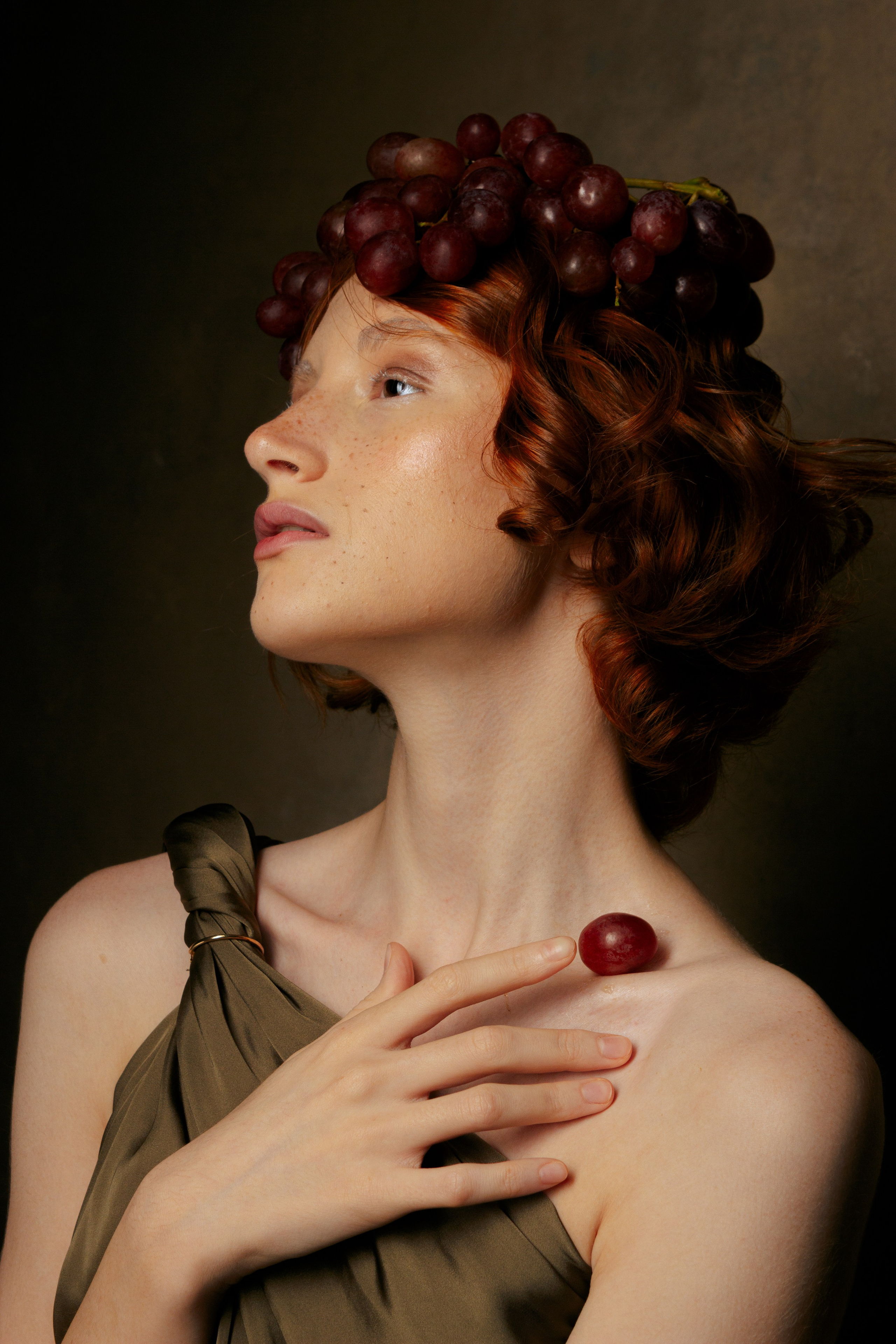 портрет рыжей девушки с гроздью красного винограда