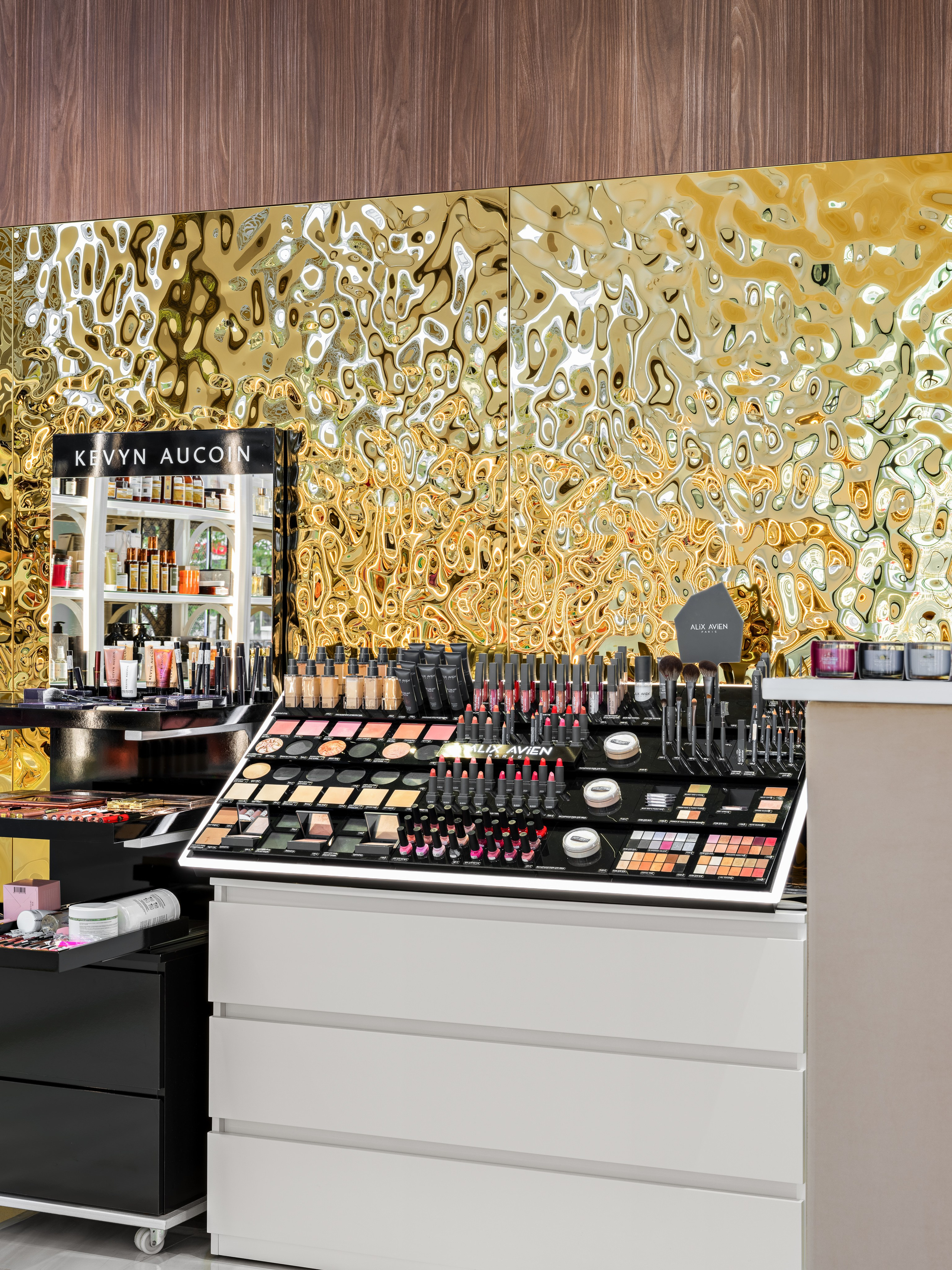 Деталь интерьера бутика: косметические витрины с декоративной золотой стеной, мраморным полом и яркой подсветкой. Современное оформление в стиле luxury, дизайнер Мария Никишина, фотограф Сергей Денисенко.
