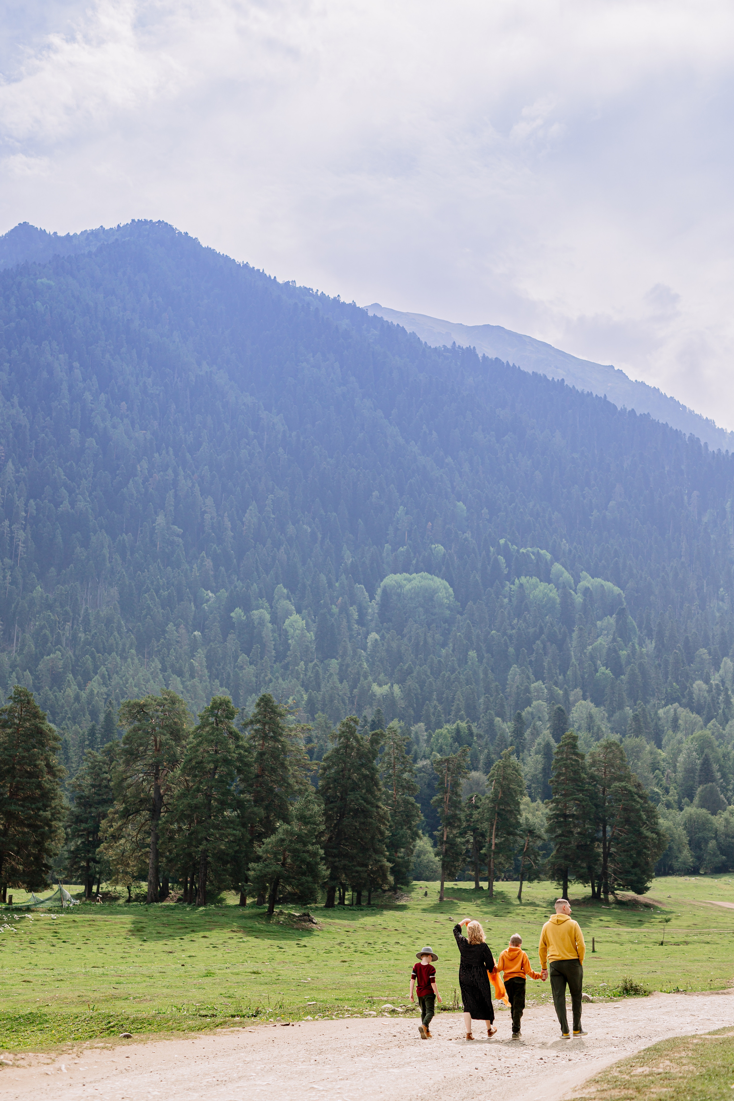 Архыз, горы, лес, семейная съемка в горах, Выездная съемка, фотограф на выезд, семейный фотограф в Астрахани, семейный фотограф,  семейный портрет в горах, семья уходит в даль по дороге к горам.